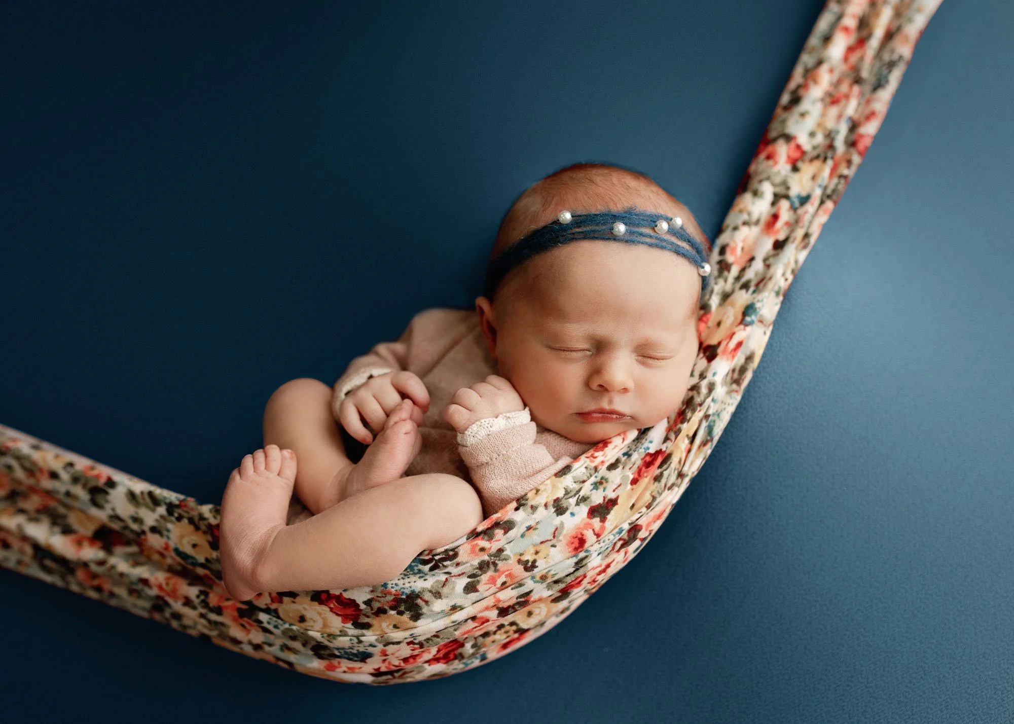 Newborn wrapped and posed in hammock with floral styling