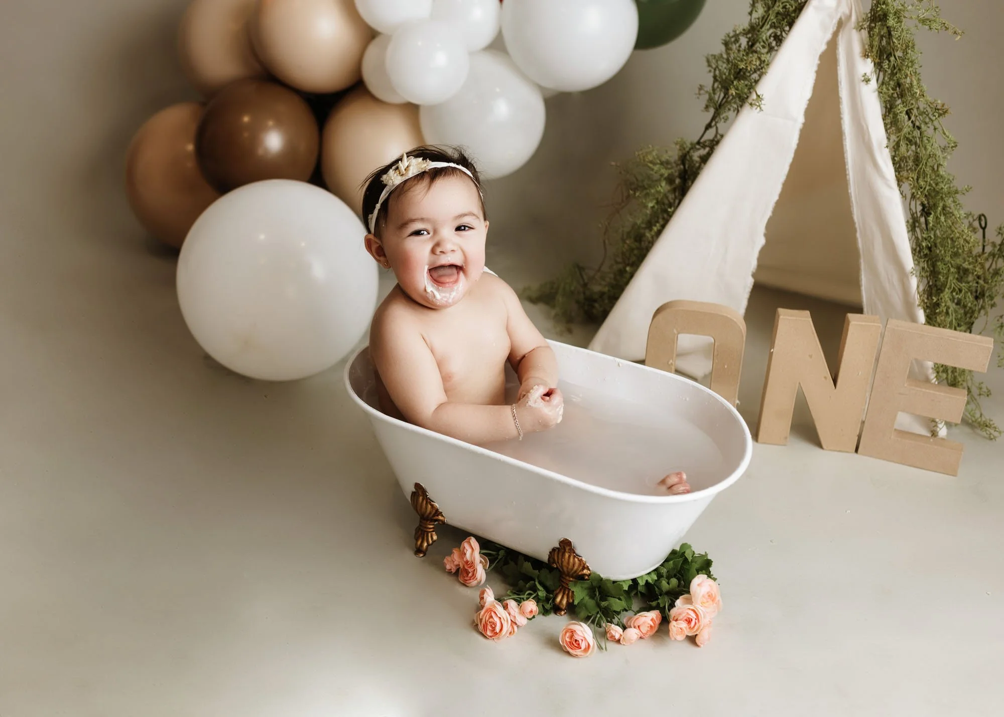 Baby enjoying neutral cake smash with minimalist studio setup