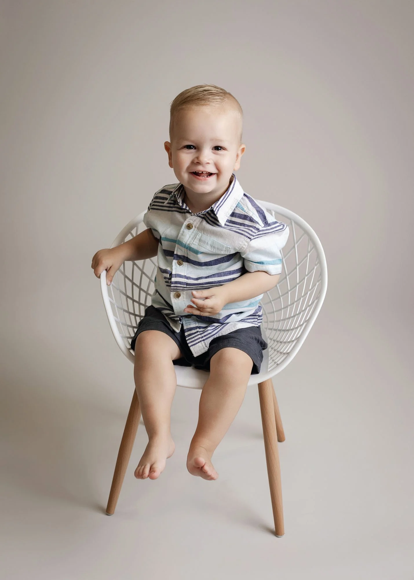 Studio milestone session with baby on white chair
