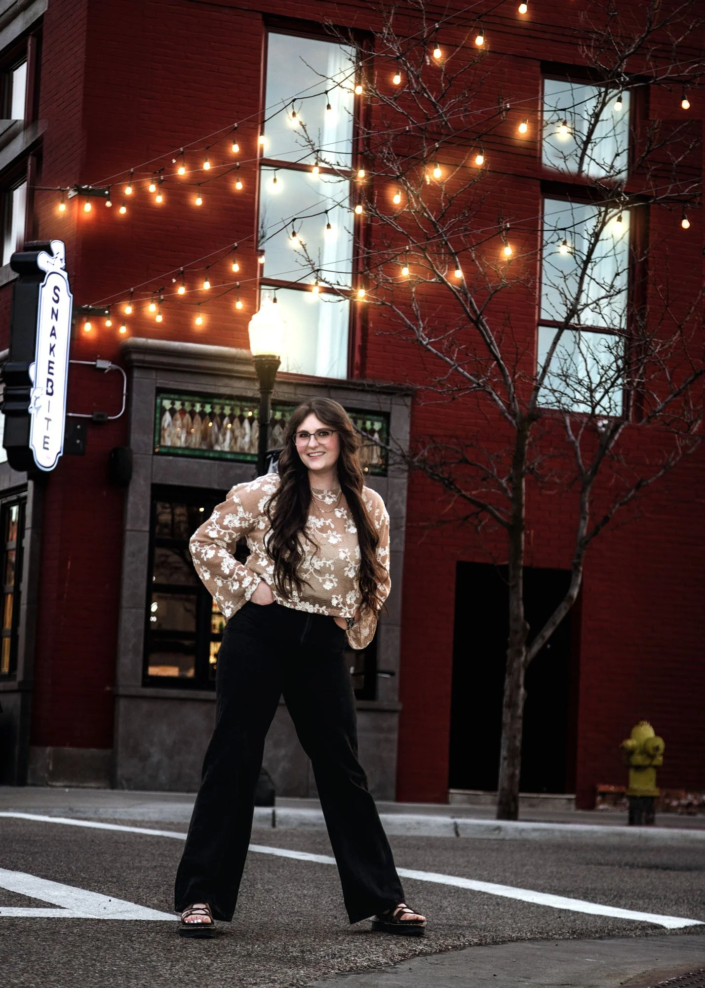 Senior girl at downtown crossroads under swaying overhead lights