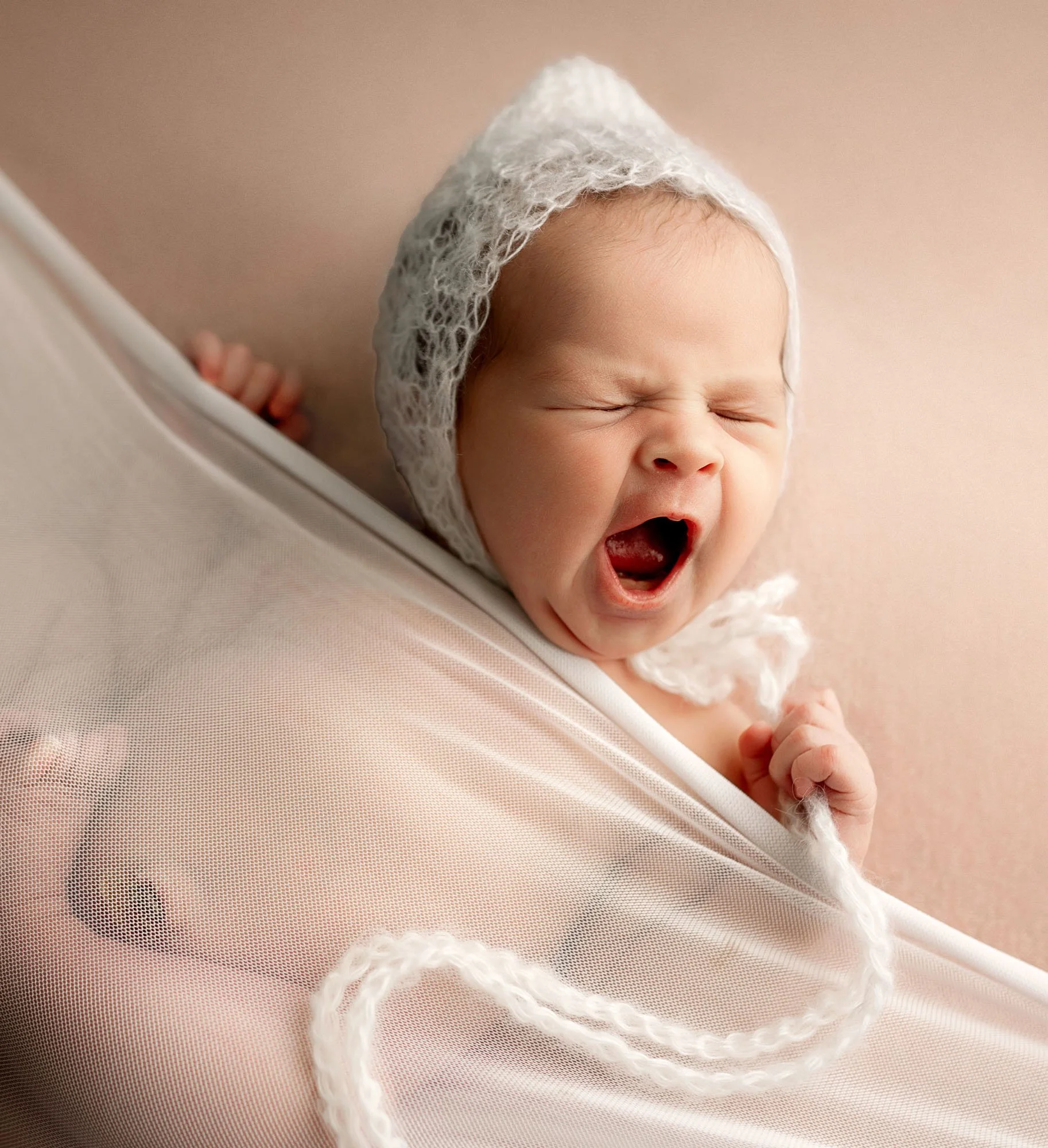 Close up of newborn baby yawning during studio session