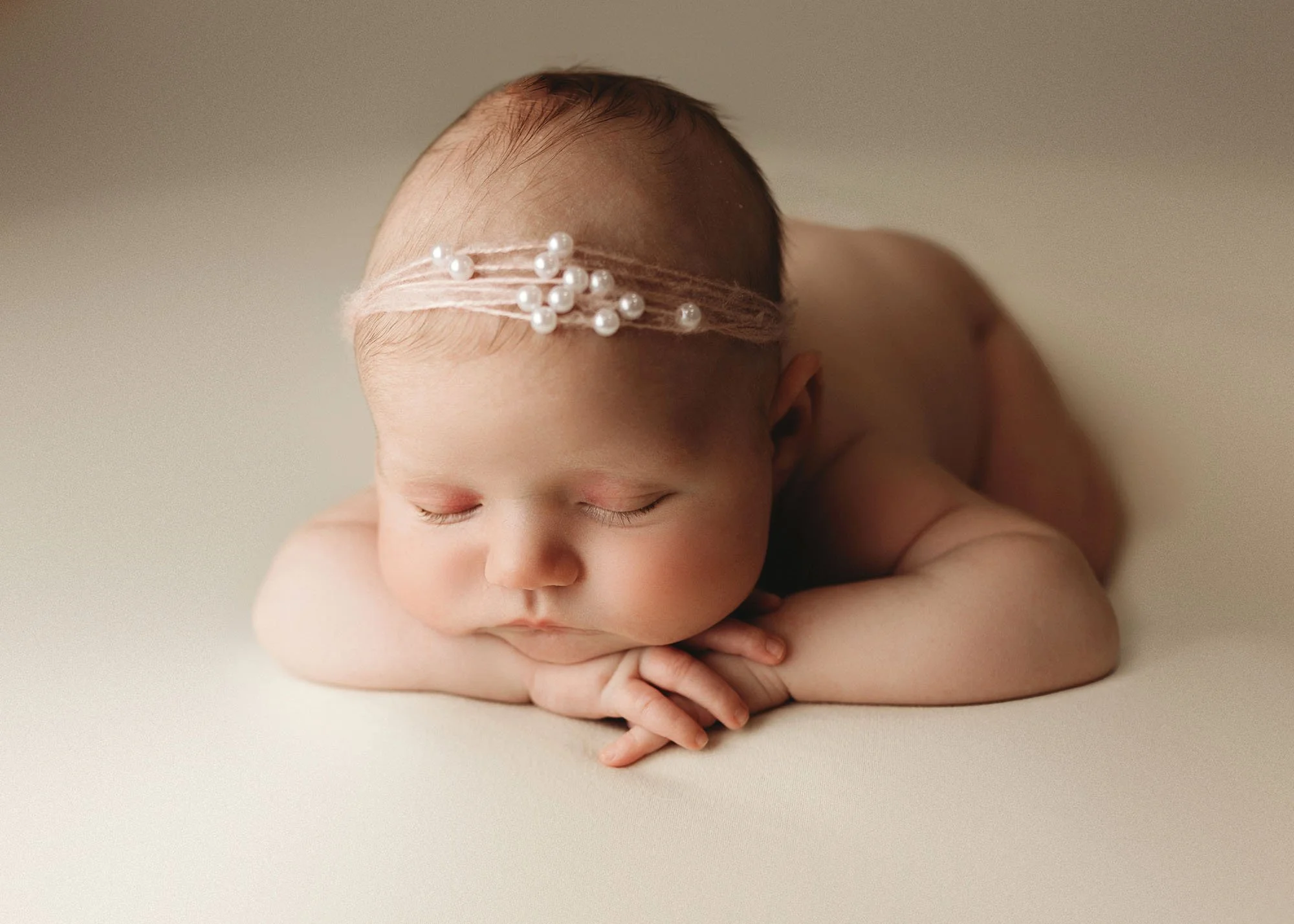 head on hands baby with pearl headband