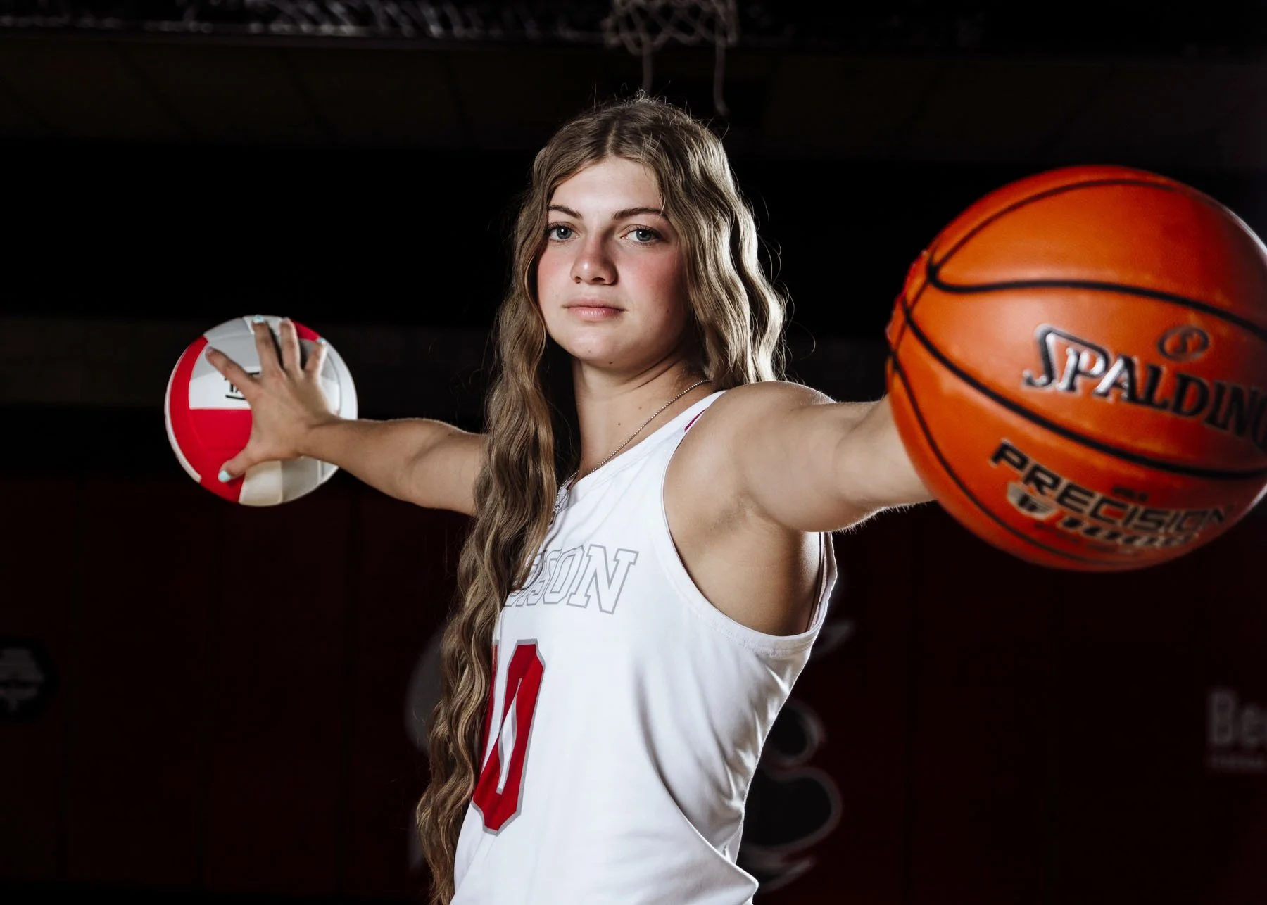 Senior girl jumping with basketball for outdoor senior portrait