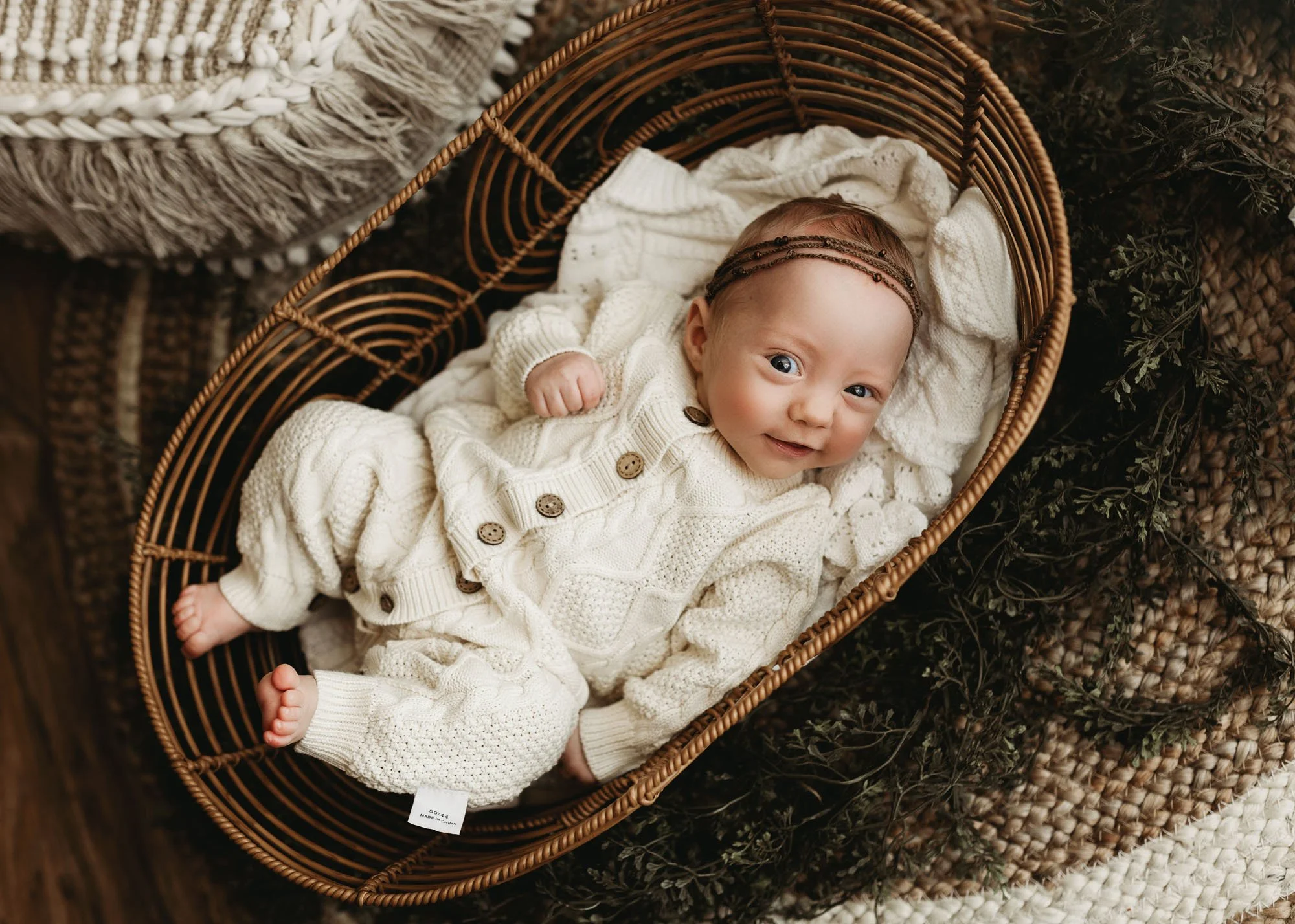 Infant lying in Moses basket during milestone photography