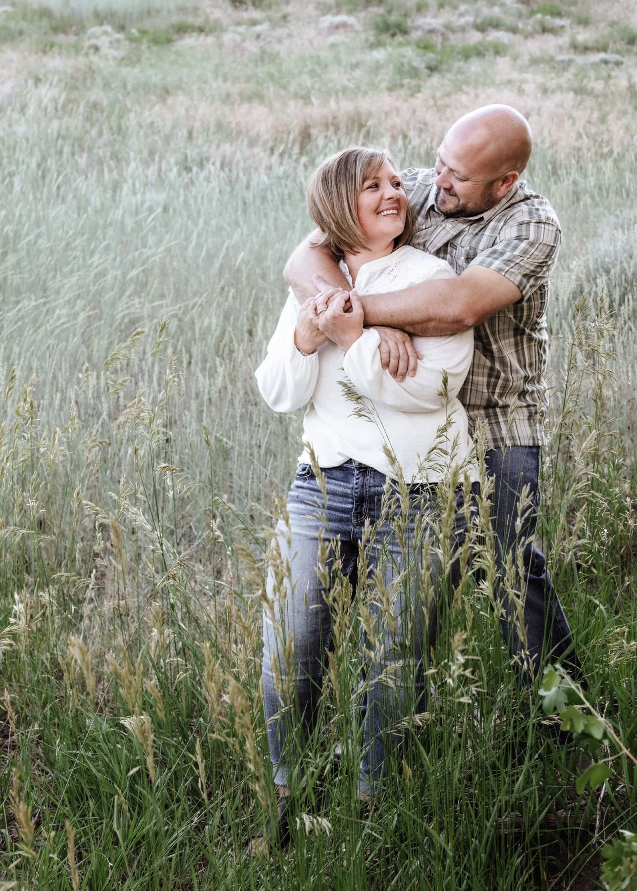 Family portrait among rocks, tall grasses, and mountains