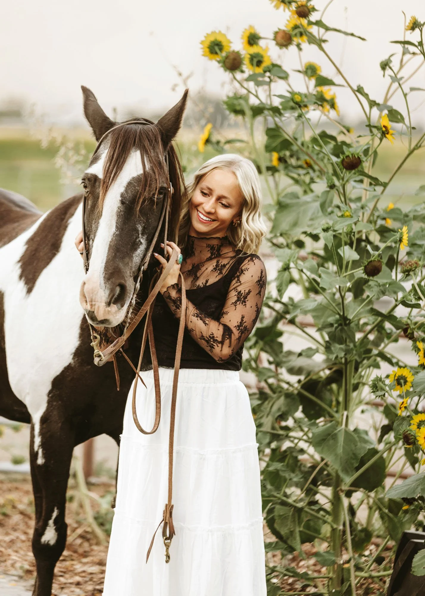 Teen girl standing with horses for outdoor senior session