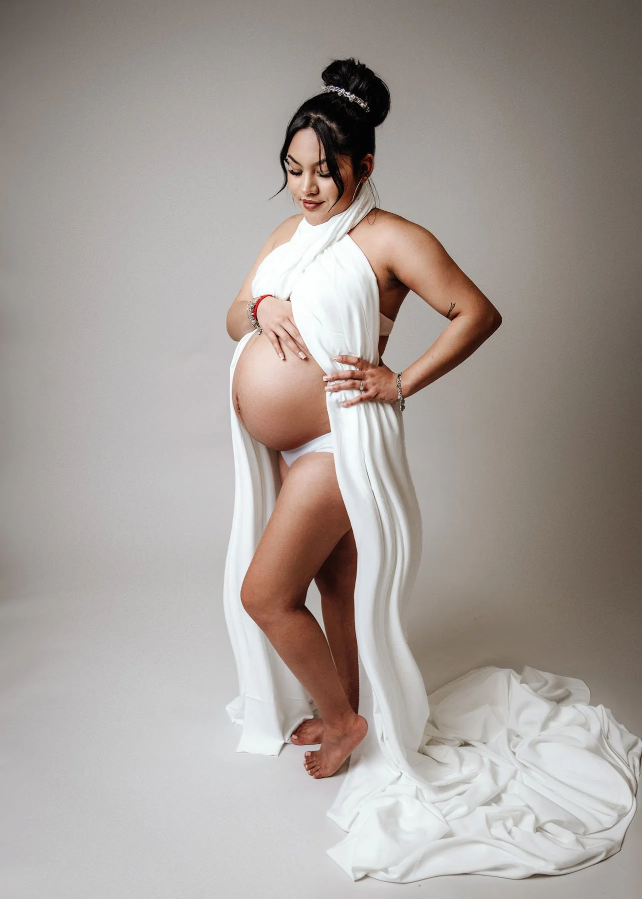 Pregnant mama in cream dress sitting and standing for maternity studio portraits