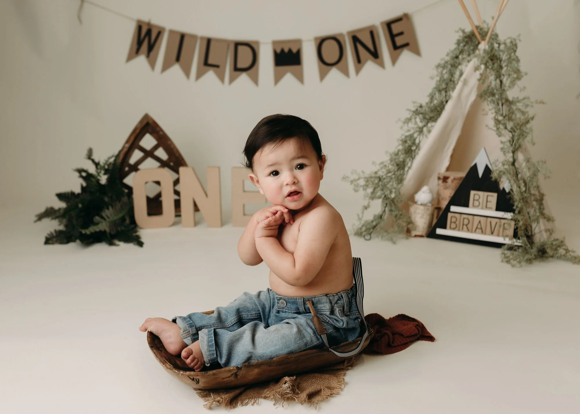 Milestone session with baby sitting in bucket on blanket