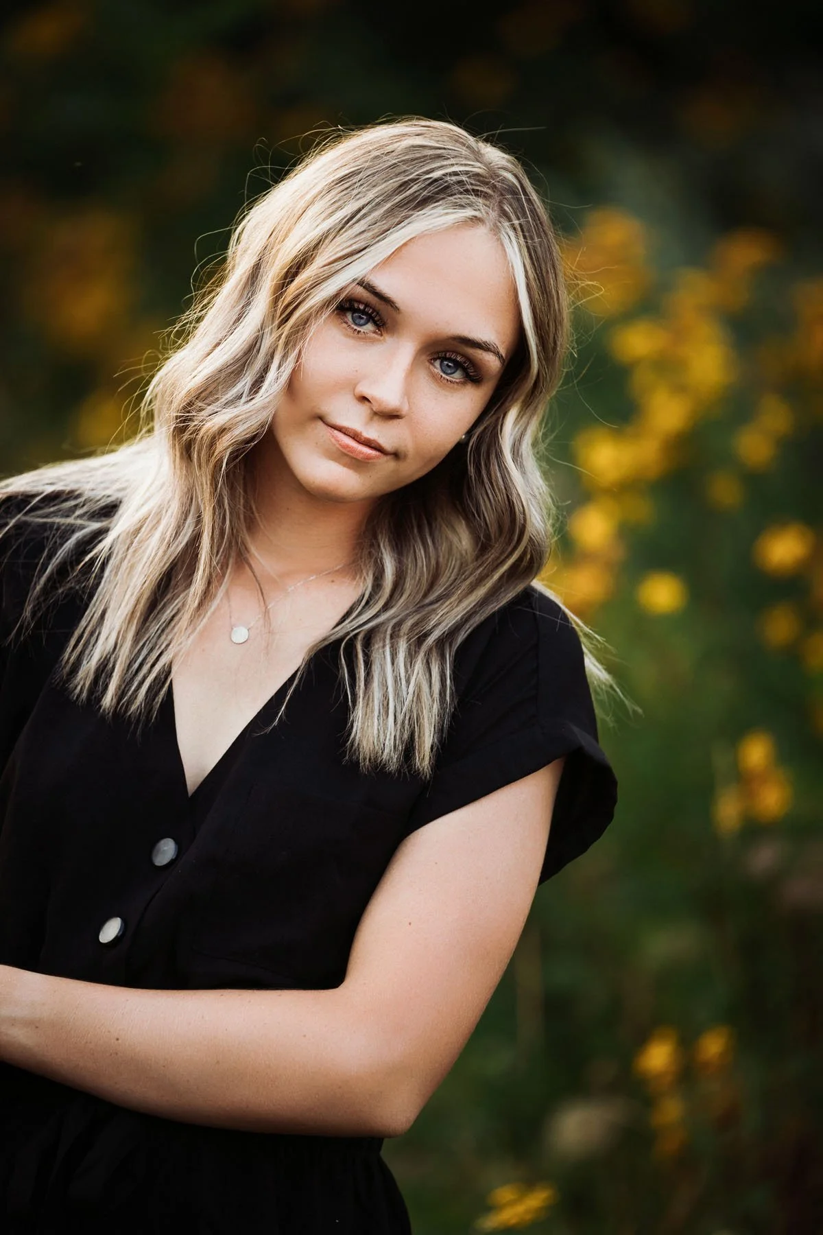 Senior girl posing with serious expression in tall grass