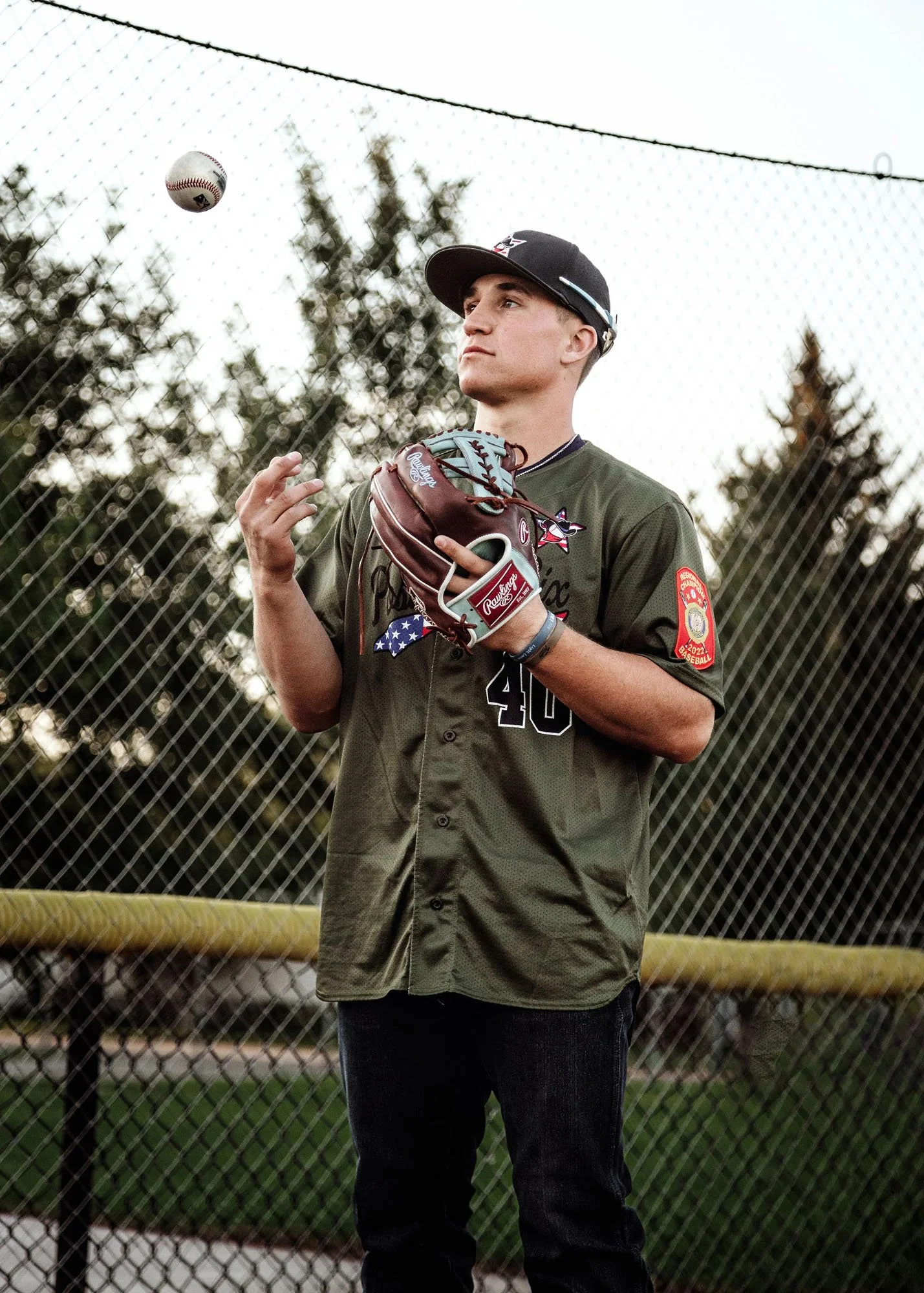 Teen boy tossing ball to himself with baseball mitt outdoors