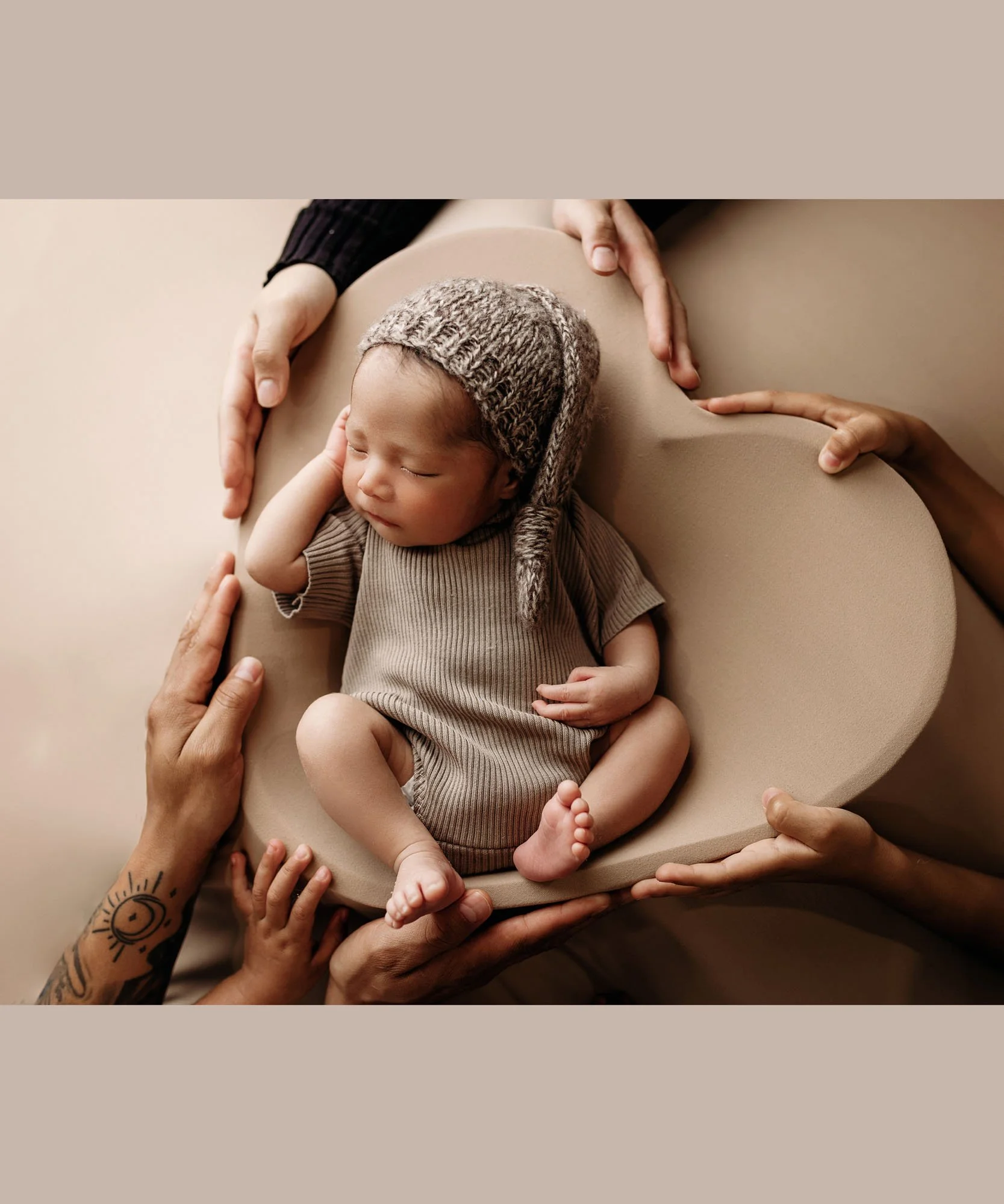 Newborn posed in heart shaped bowl prop during studio newborn session