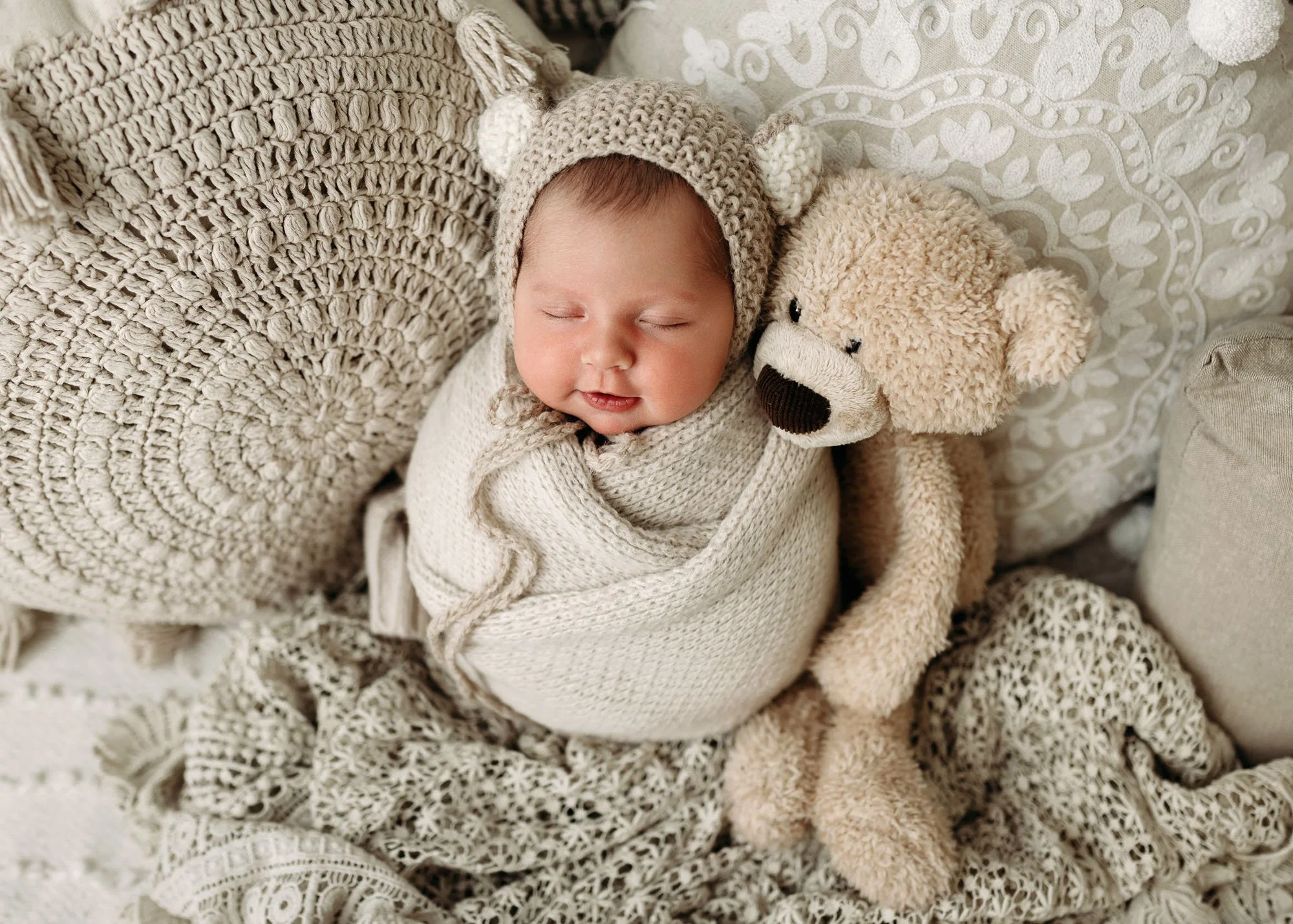 Newborn wrapped and laying on back with arms and legs peeking out