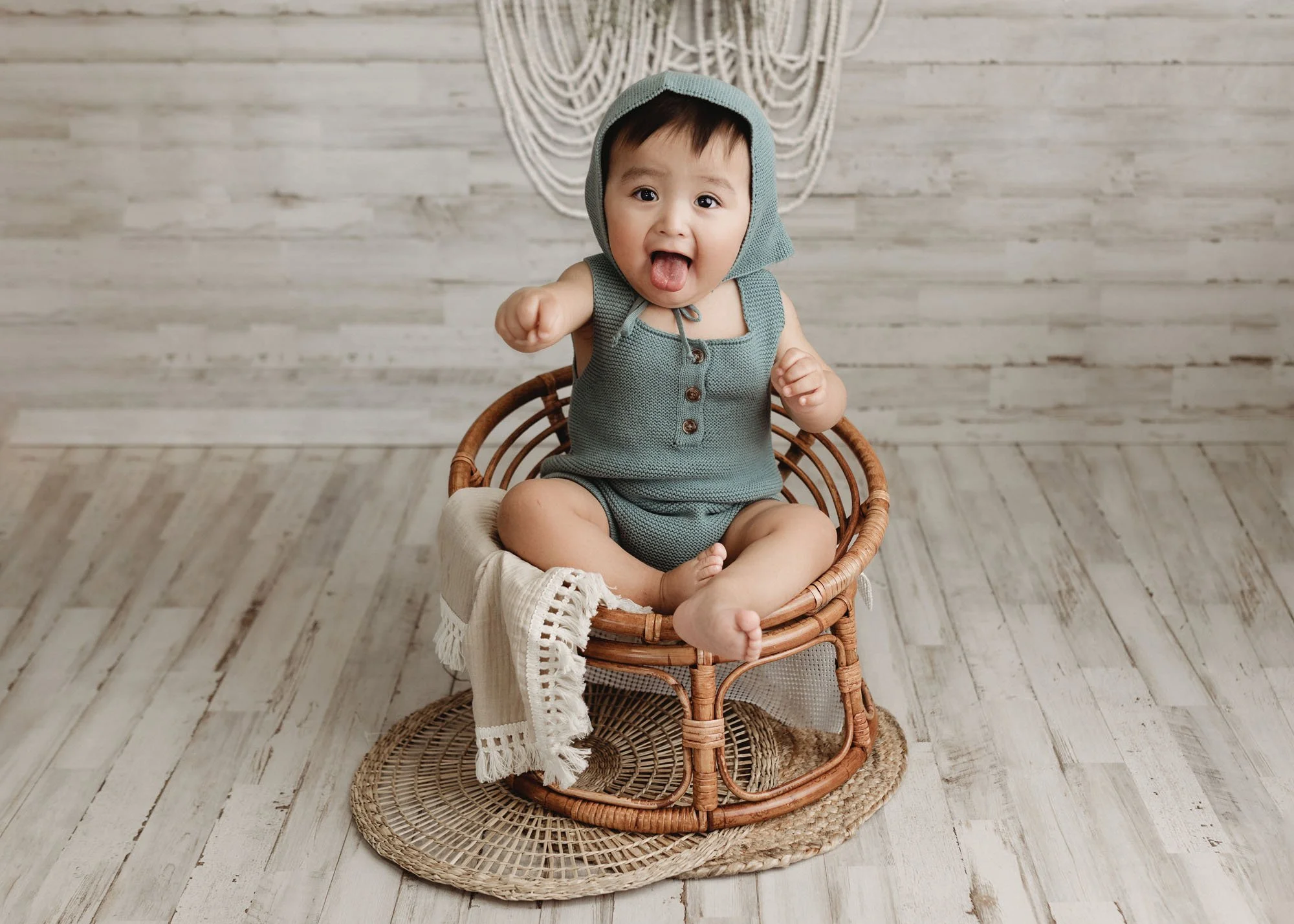 Baby sitting on rustic wooden chair for milestone session