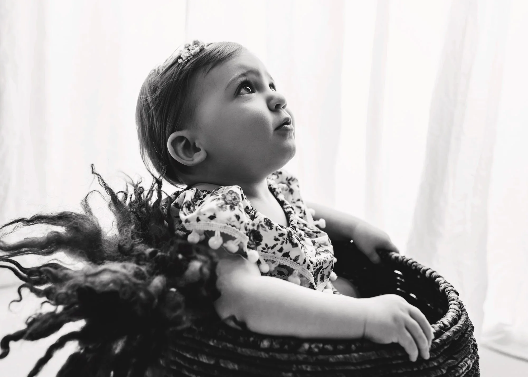 Infant milestone photo with baby in studio bucket