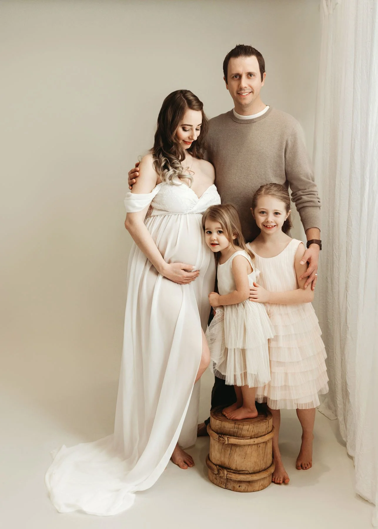 growing family in neutral colors by window