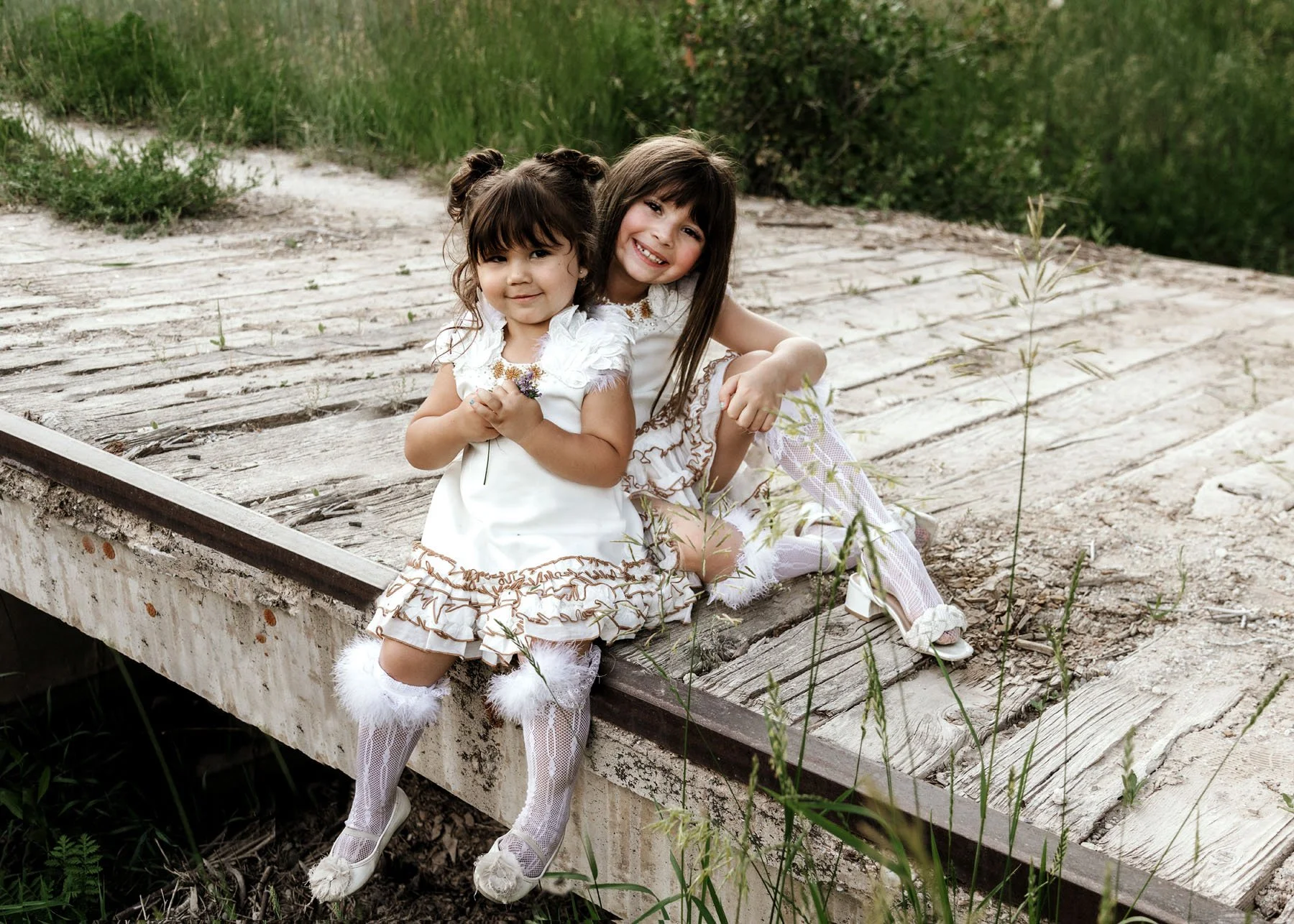 Family standing on wooden bridge with rocks and greenery
