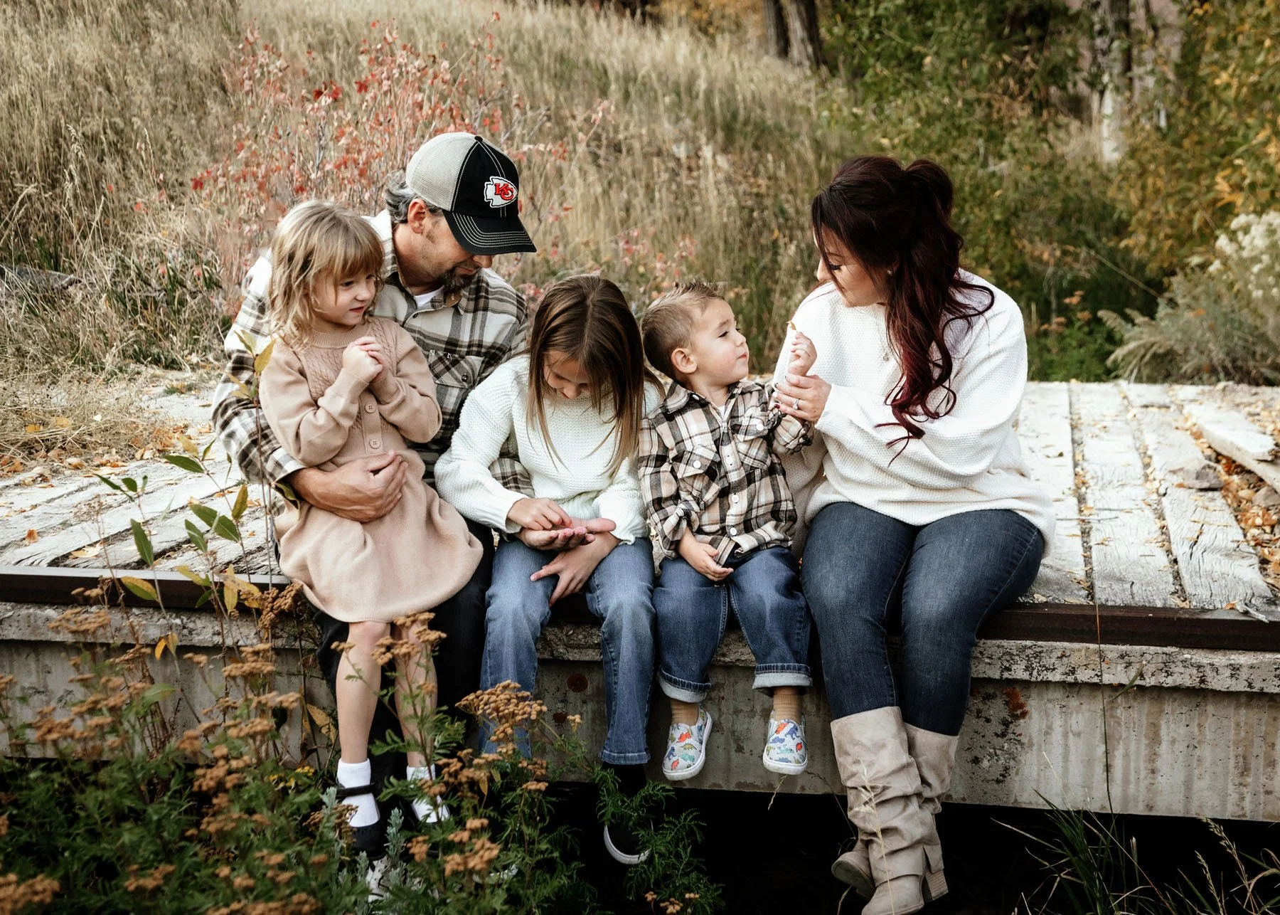 Children playing with parents on a rustic bridge setting