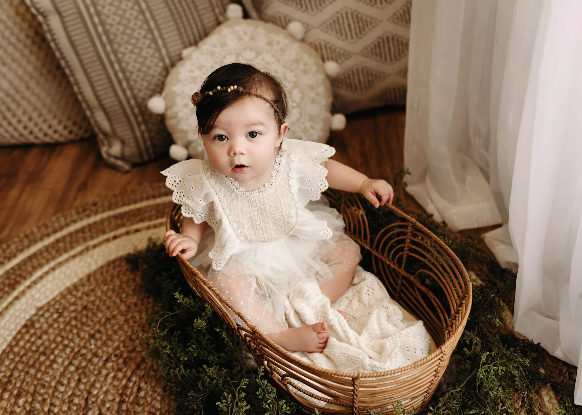 Infant milestone photography in Moses basket on soft blanket