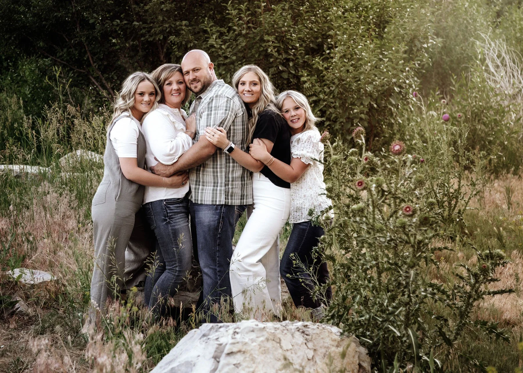 Parents and kids laughing together in natural outdoor setting