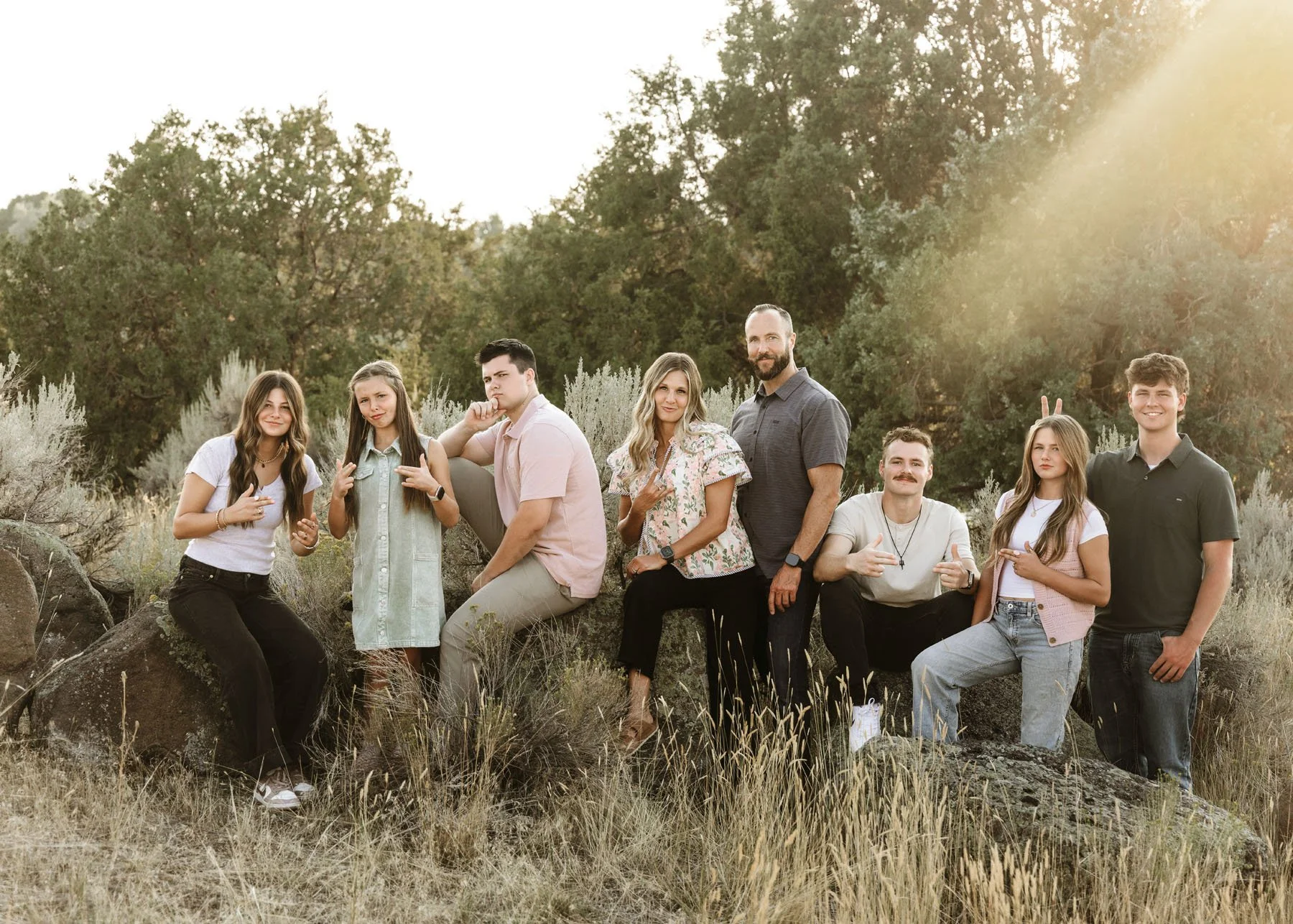 Family standing together among tall grasses and rocks
