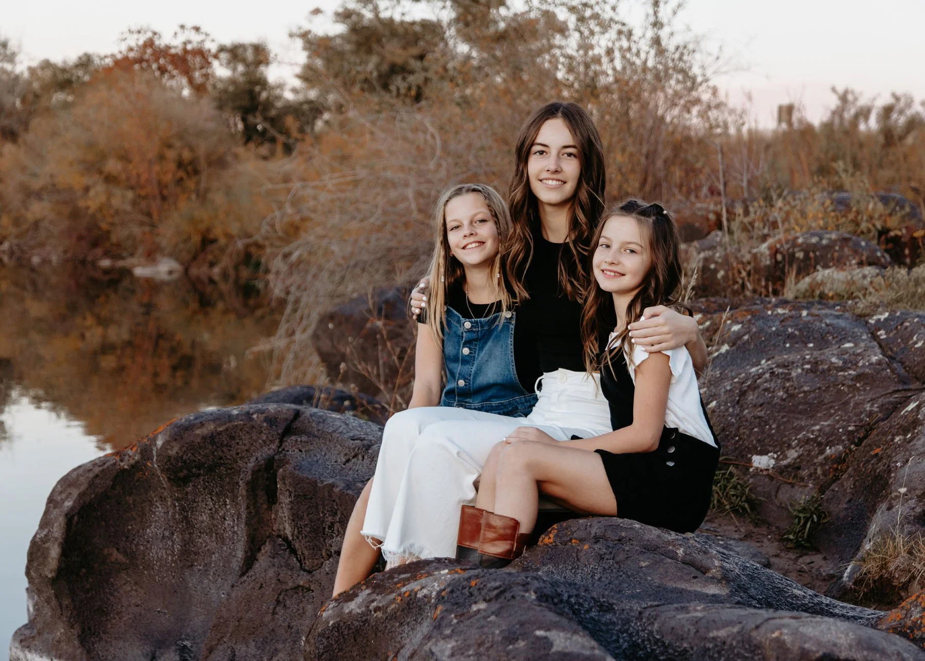 Kids and parents enjoying natural scenery by river rocks