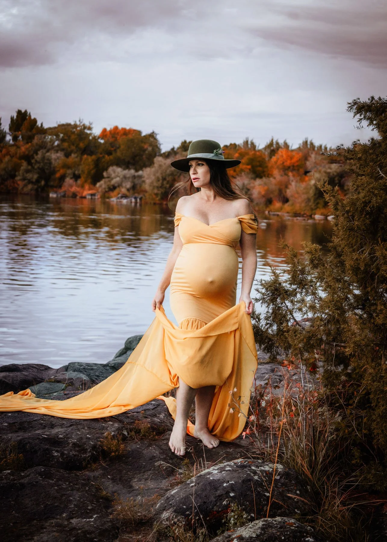 mama in yellow dress by river holding baby bump
