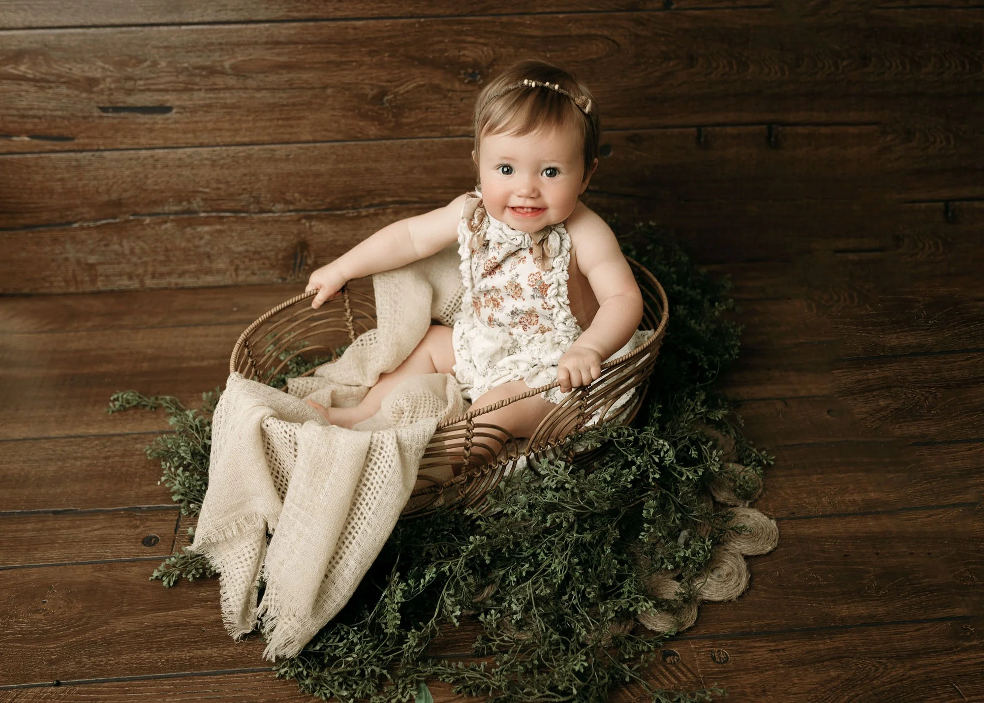 Baby lying in Moses basket in front of cozy bed