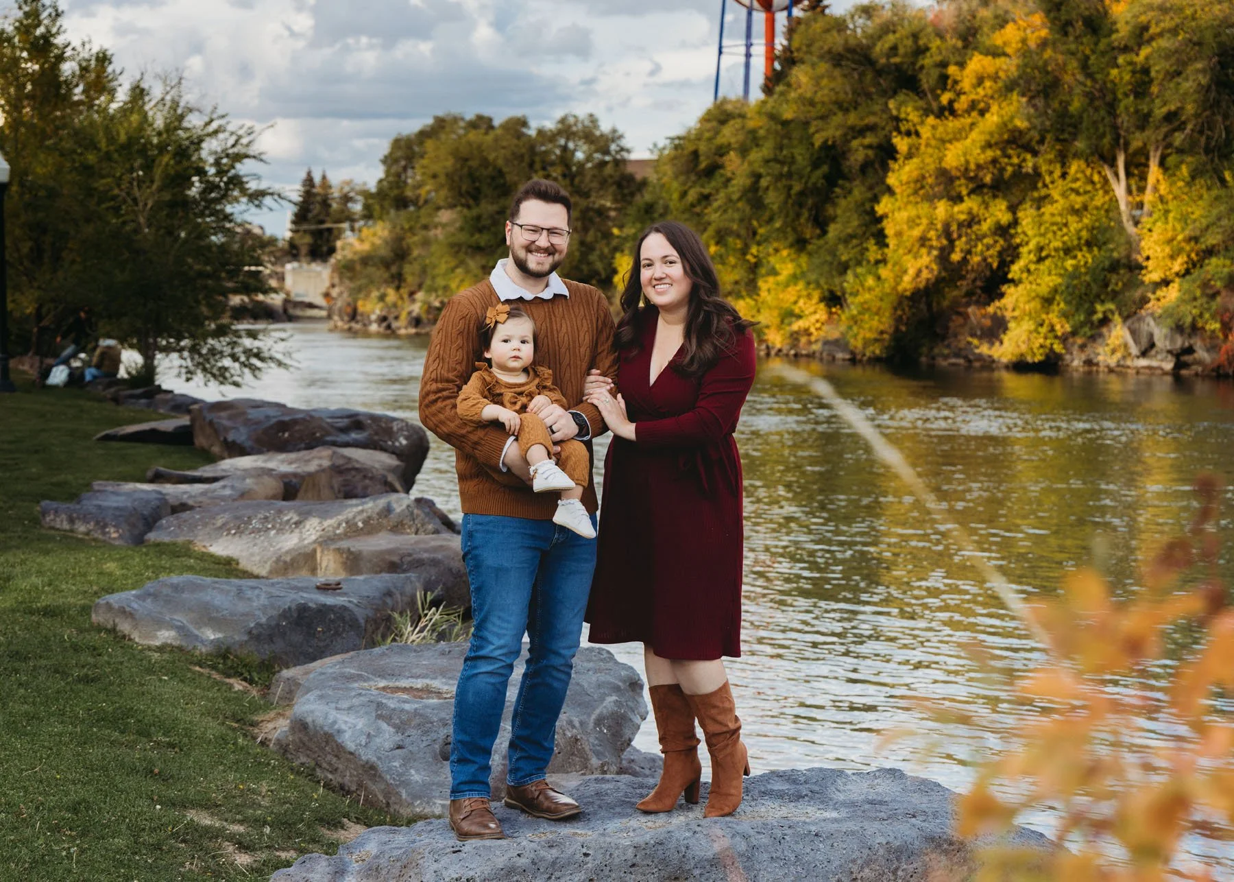 Parents and children standing on rocks by a flowing river
