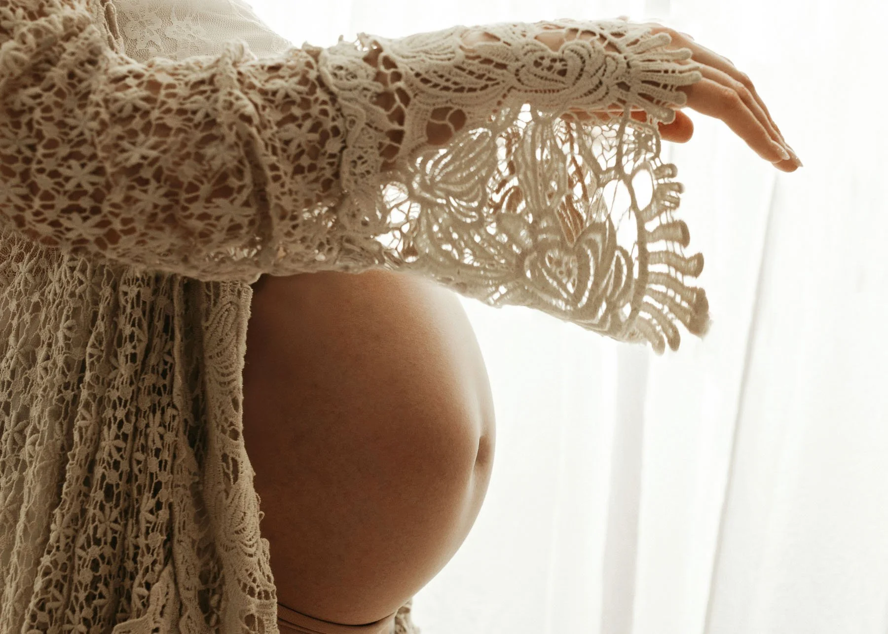 Pregnant mama profile showing baby bump in lace dress