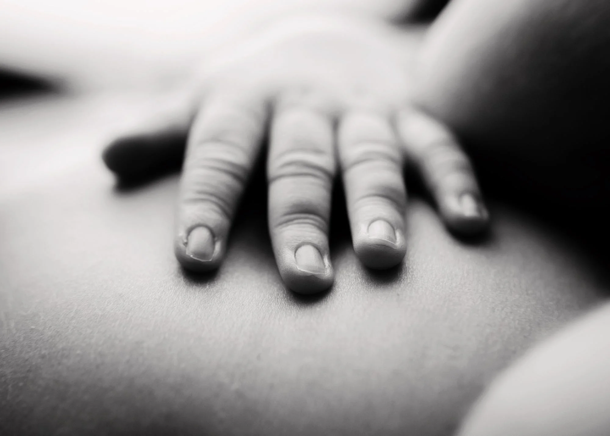 Close up detail of newborn hands and soft baby skin wrinkles