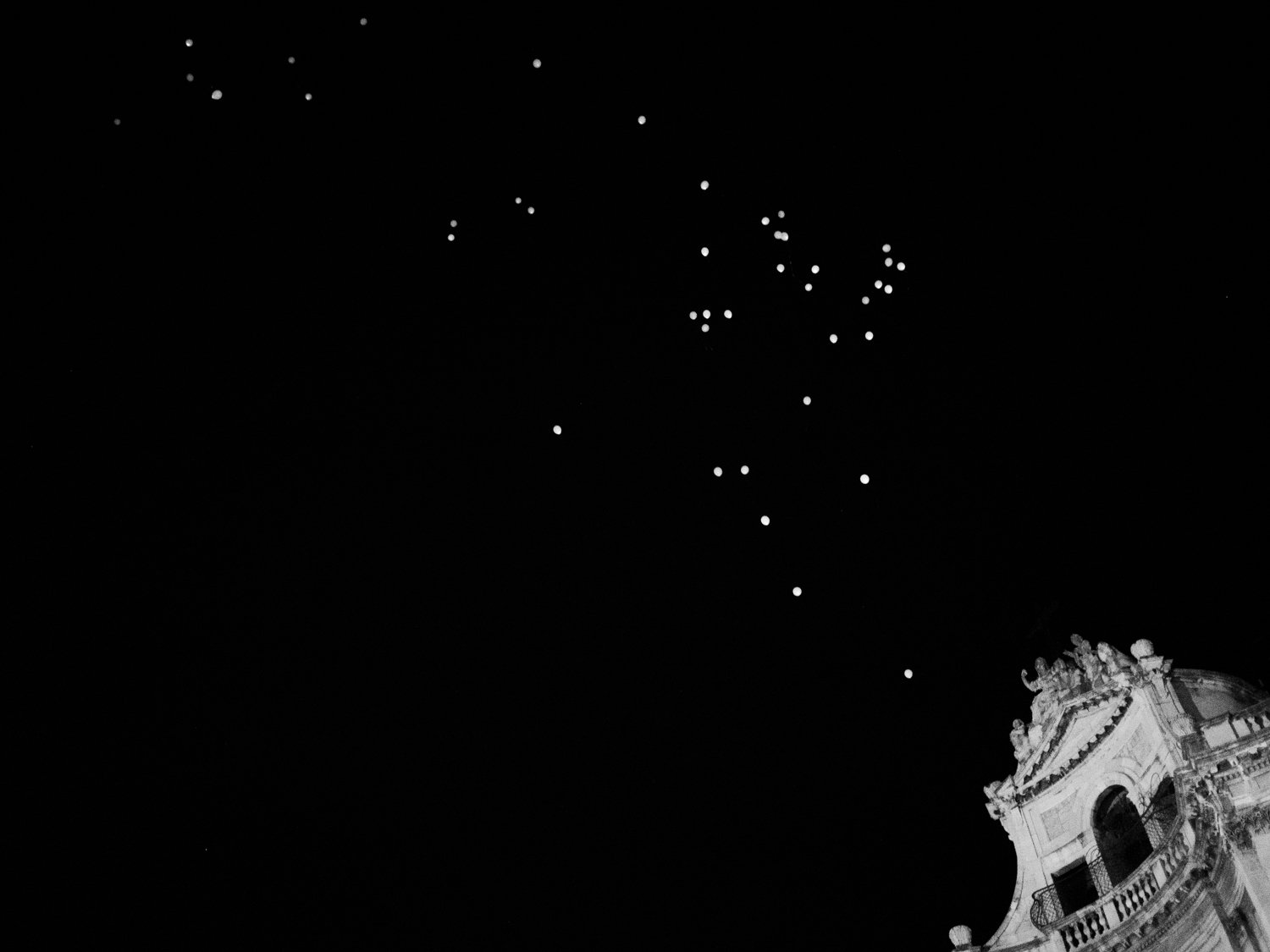Italy. Sicily. August 2015. Forty-nine balloons are freed in the sky over S. Agata's church in Catania to remember the victims, migrants and refugees, drowned in the Mediterranean Sea two days earlier during an attempt to reach the European Union.