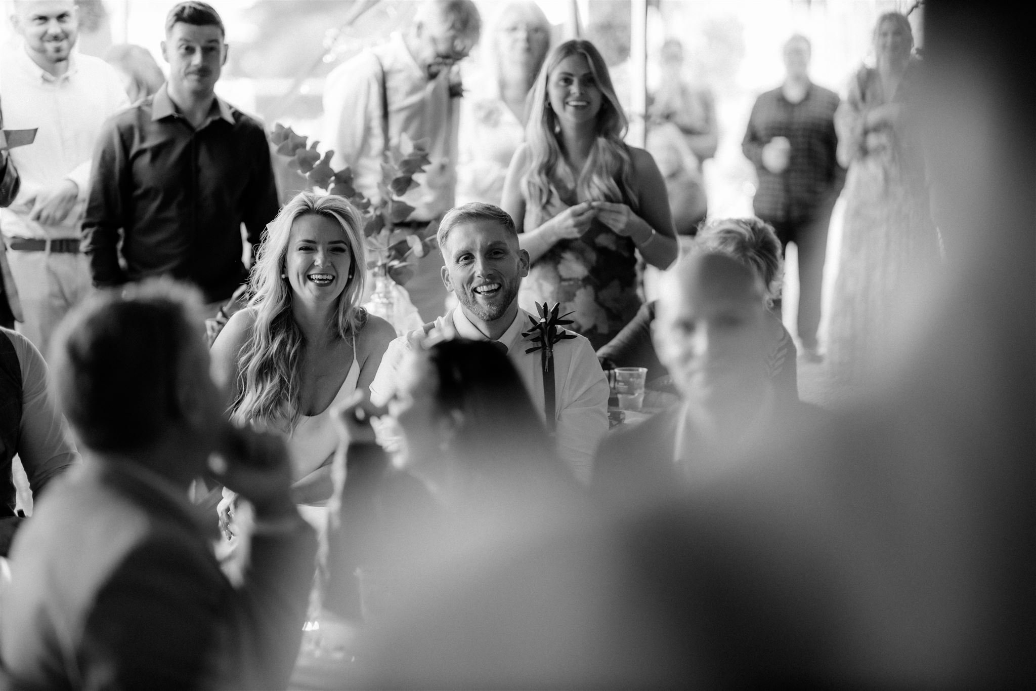 Group of people laughing and smiling at a social event in black and white
