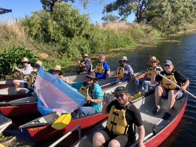 Trans Day of Visibility Canoe Day. Warrnambool community members holding trans falg as they launce their canoes.