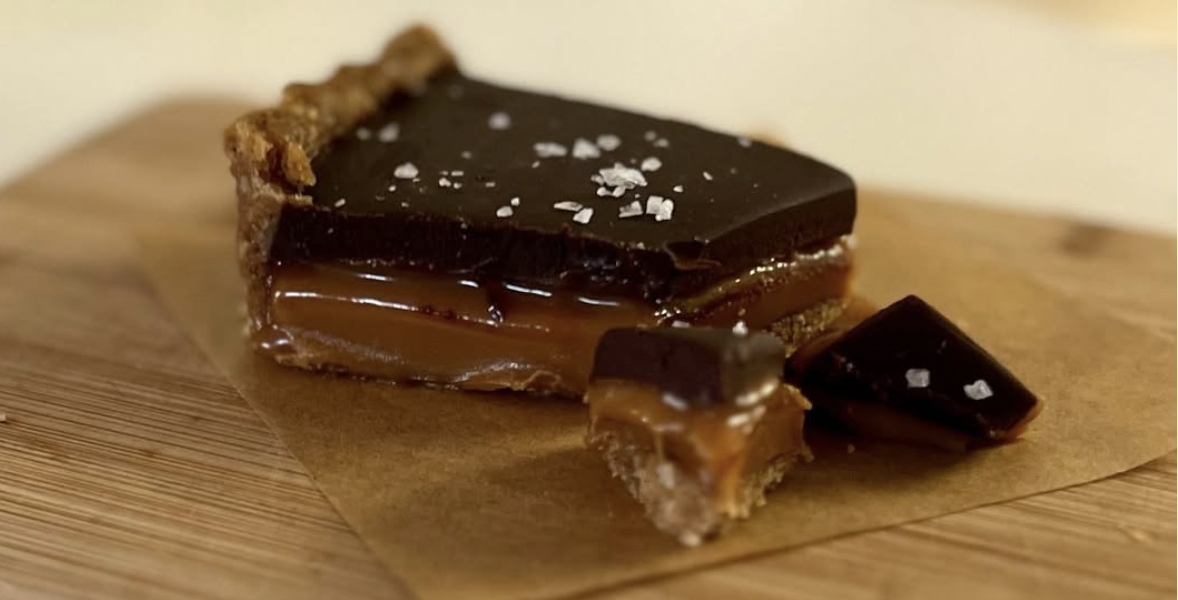 Ginger spiced oat crust with a layer of caramel dark chocolate ganache layer and flake salt