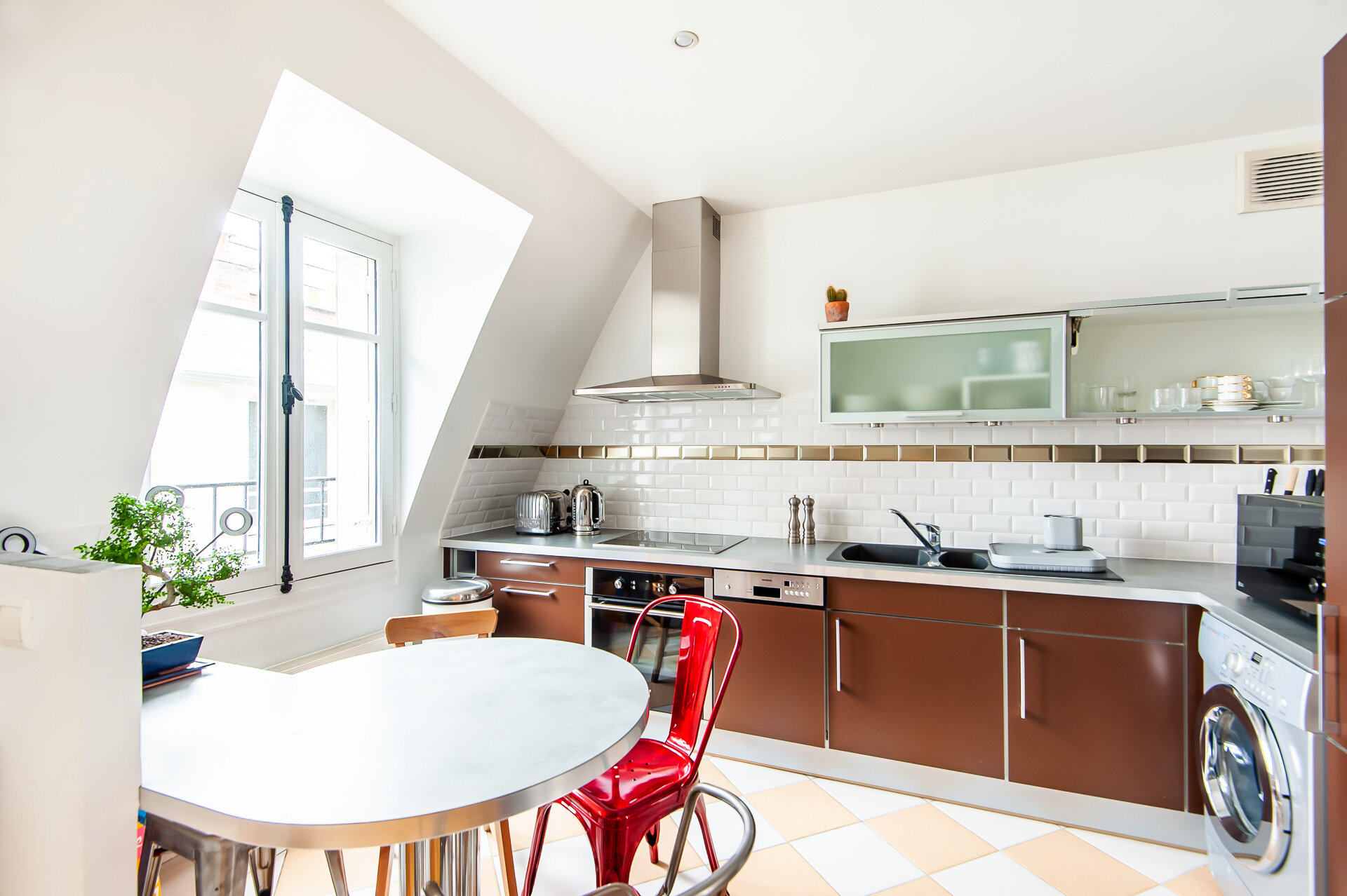cuisine ouverte équipée d'un appartement atypique en duplex à Paris 17ème, lumière, calme, parquet, chaise Tolix