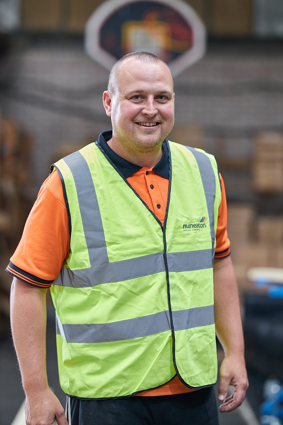 Person wearing a reflective safety vest in a warehouse setting.