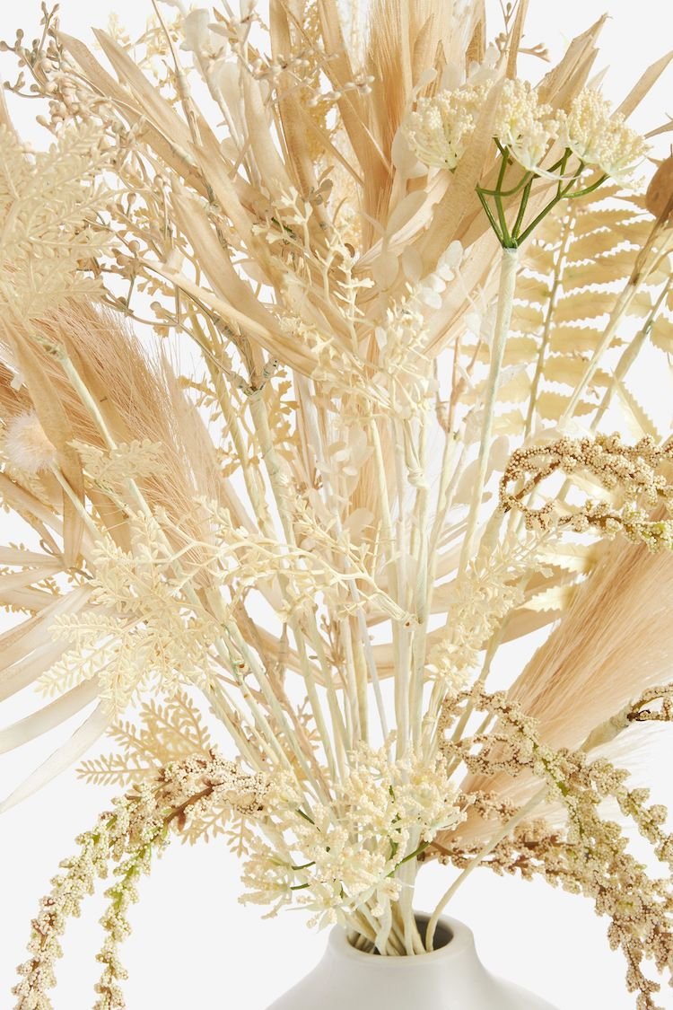 Dried flowers bouquet in neutral tones in a white vase