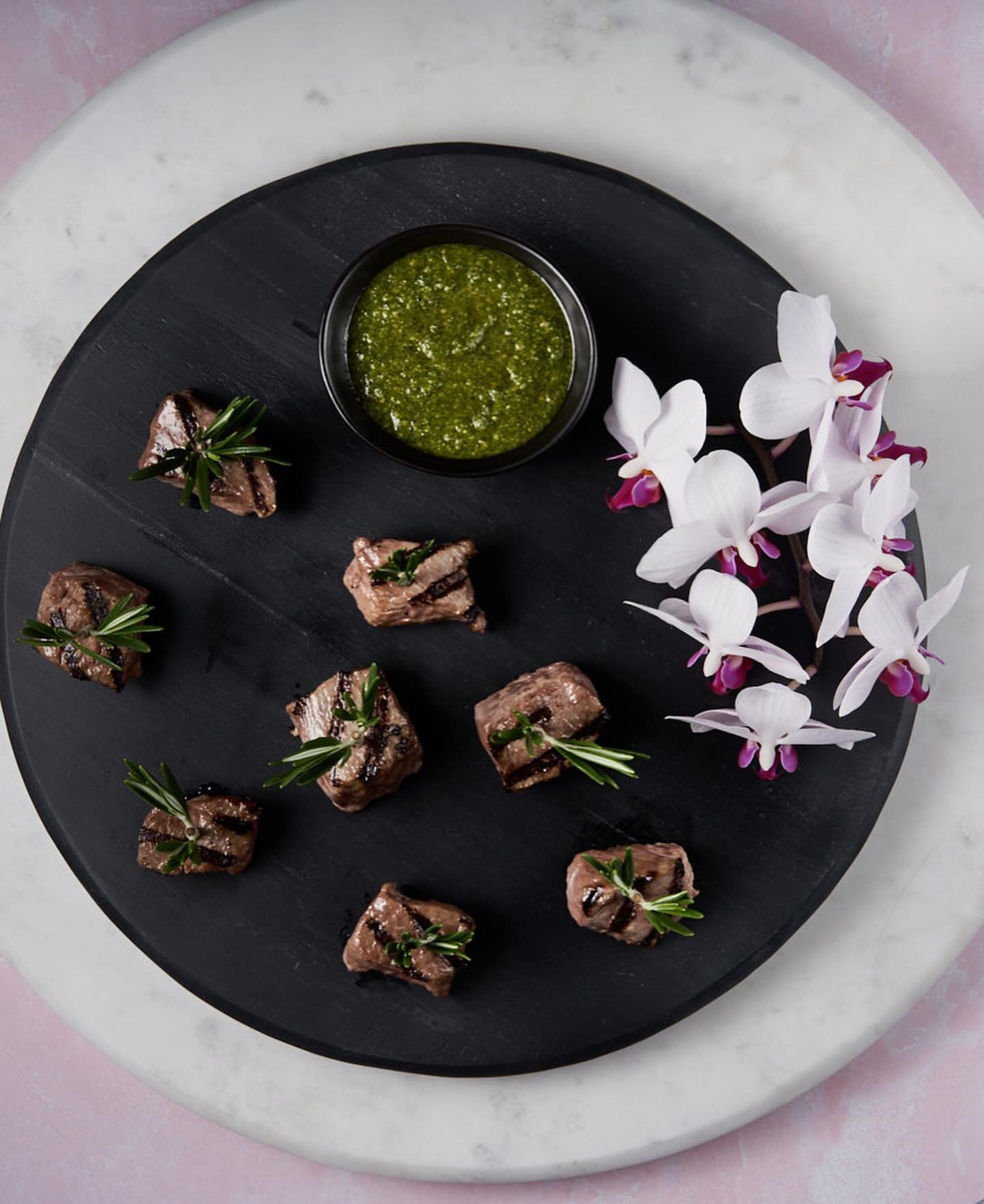 Savor the Elegance: Grilled Lamb Hors d&rsquo;Oeuvre

Indulge in the refined flavors of our chic grilled lamb hors d&rsquo;oeuvre, expertly seared to perfection and adorned with fresh rosemary sprigs for a touch of aromatic sophistication. Paired wit