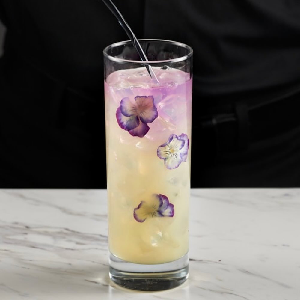 Spring is about to be in full bloom &mdash; and so is our newest creation.
We had fun behind our bar can&rsquo;t you tell ?  A refreshing, floral-forward cocktail that&rsquo;s almost too pretty to sip (almost).
Can you guess what&rsquo;s inside? Here