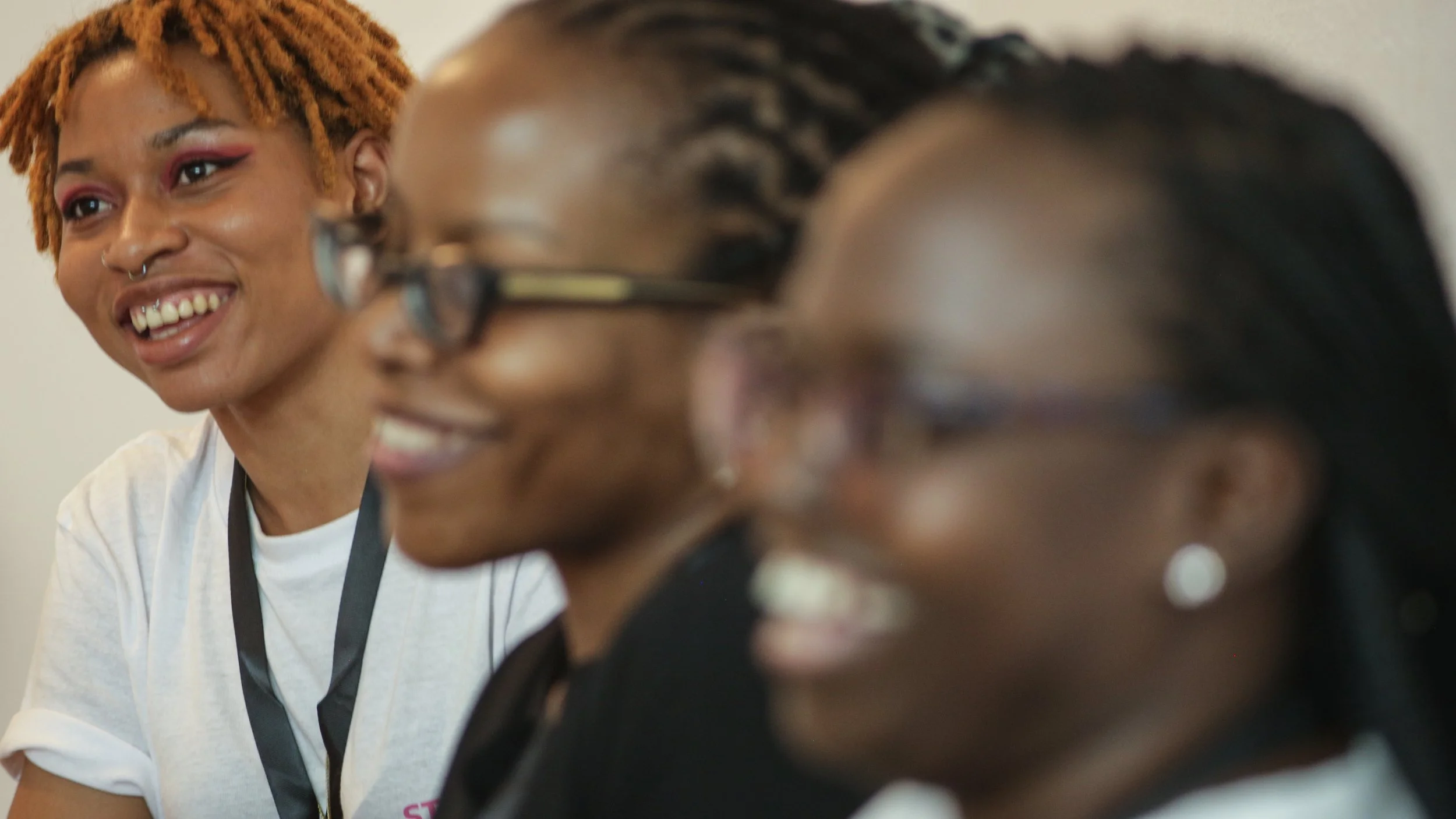 Image shows 3 participants smiling in the 2023 Global Gathering