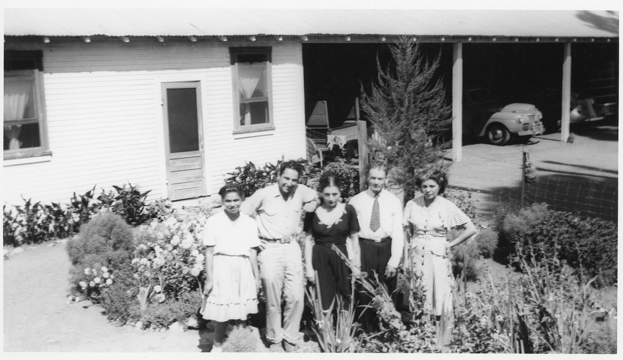 Rose Mary Sanchez (left) and friends posing beside her residence