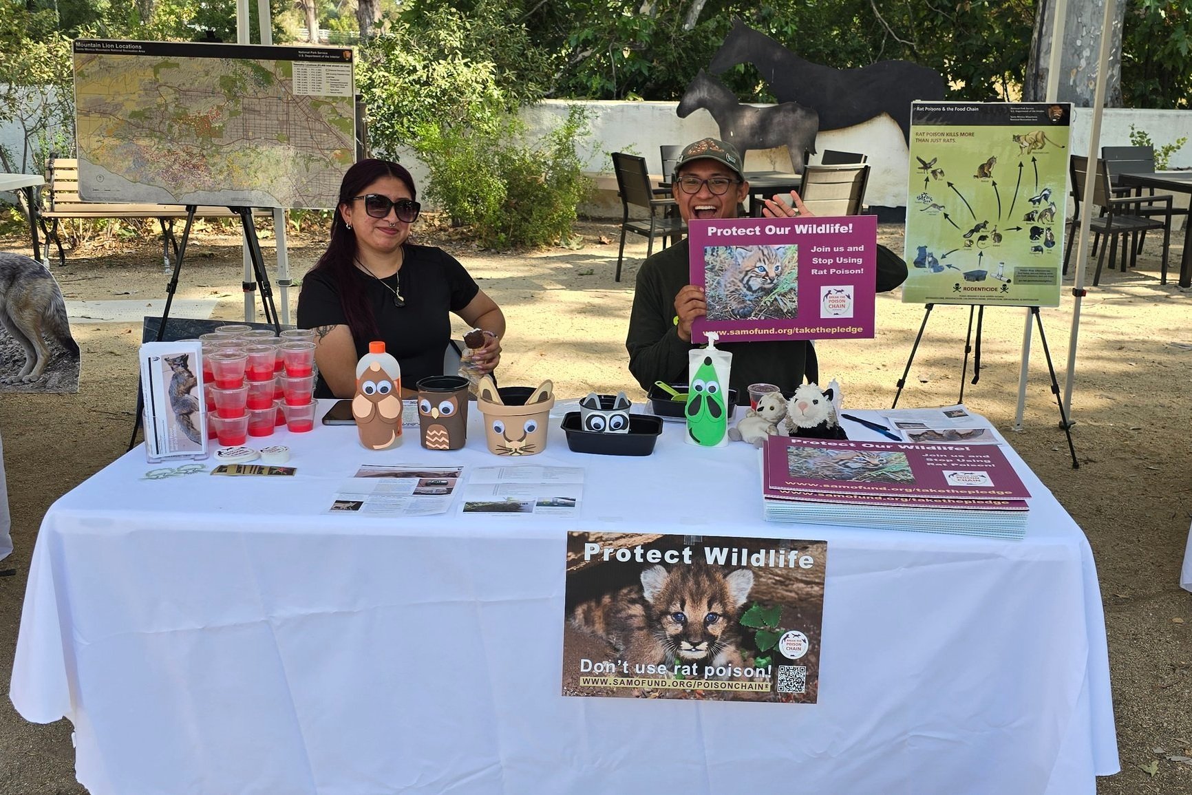   SAMO Youth and California Naturalist Alumni, Alec Zapata alongside SAMO Youth Alumni, Jaquelin Muniz present a hands-on activity displaying the harm of rodenticides to local wildlife. The activity showcased how rodenticides are passed through the food chain, turning it into a “poison chain” across multiple animal species moving up the food web.    Zapata offered up alternatives to using rodenticides/ rat poison while also handing out SAMO Fund ‘Break the Poison Chain’ lawn signs for anyone interested in sharing the new lessons they learned!  