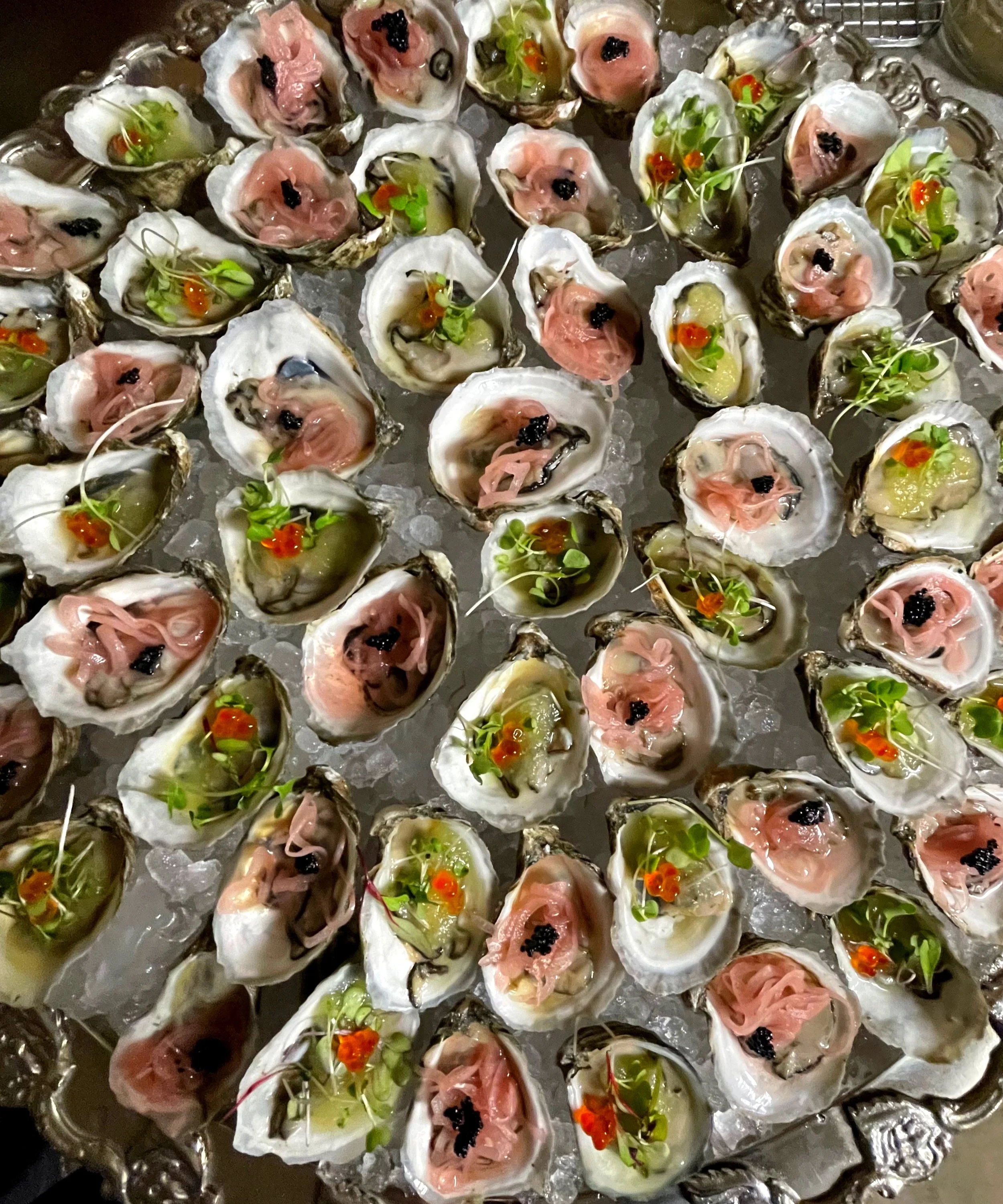 Plate of oysters with garnishes on ice
