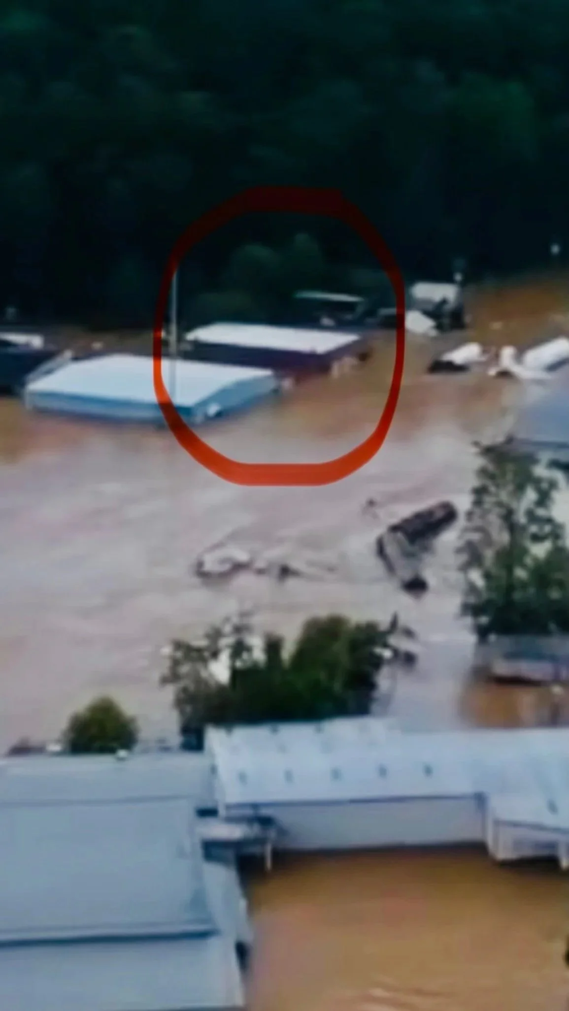 Aerial image showing the studio building at 4 Mulvaney Street in Asheville, North Carolina, flooded up to the top floor during Hurricane Helene.