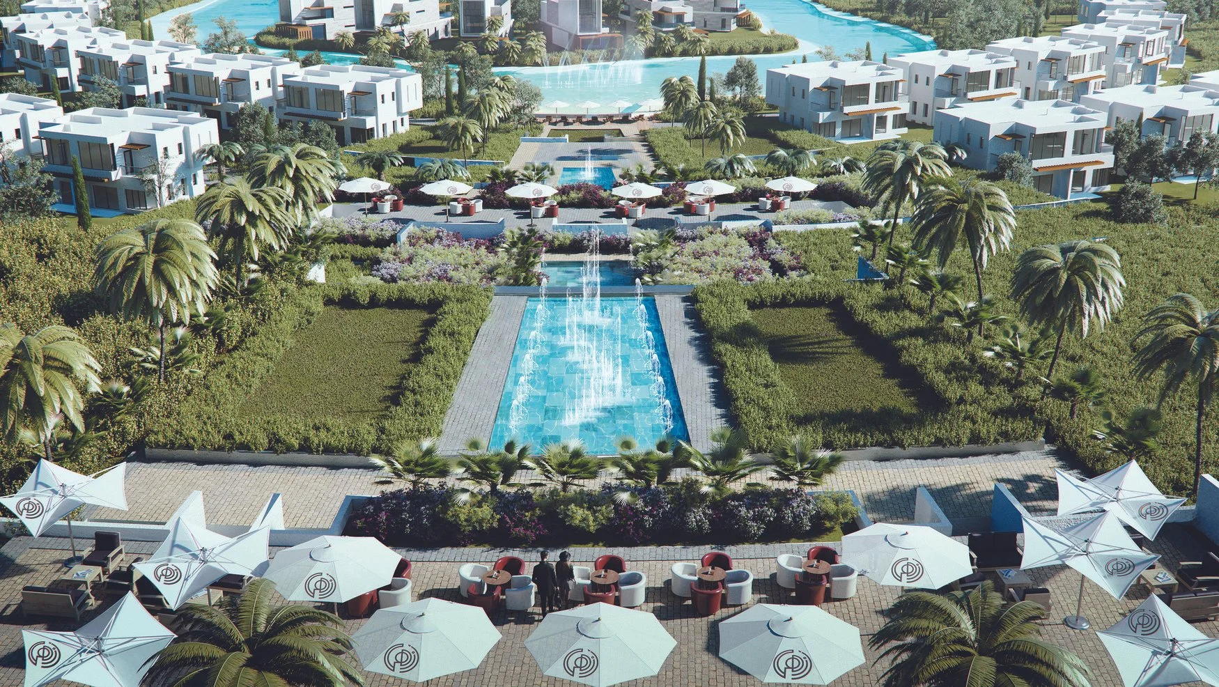 A luxury resort pool area with multiple fountains, surrounded by palm trees and lounge chairs with umbrellas, and modern white buildings in the background.