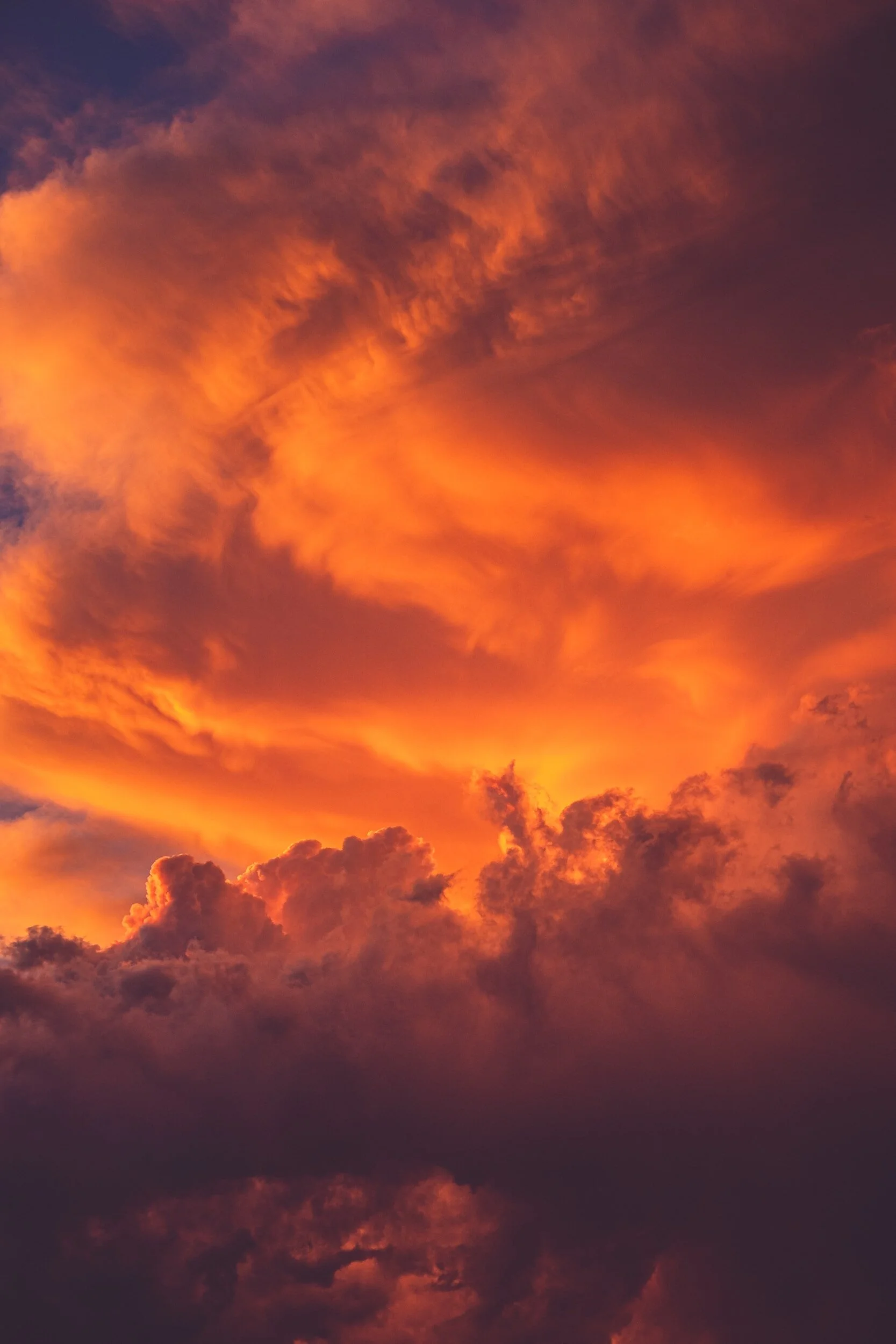 A vibrant sunset sky with orange, purple, and red clouds