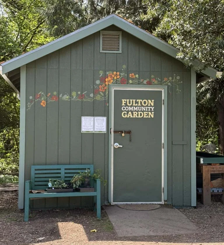 Dark green garden shed with nasturtium mural