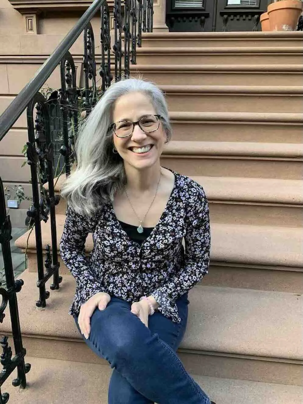 Carol Covelli, LCSW sitting on stairs