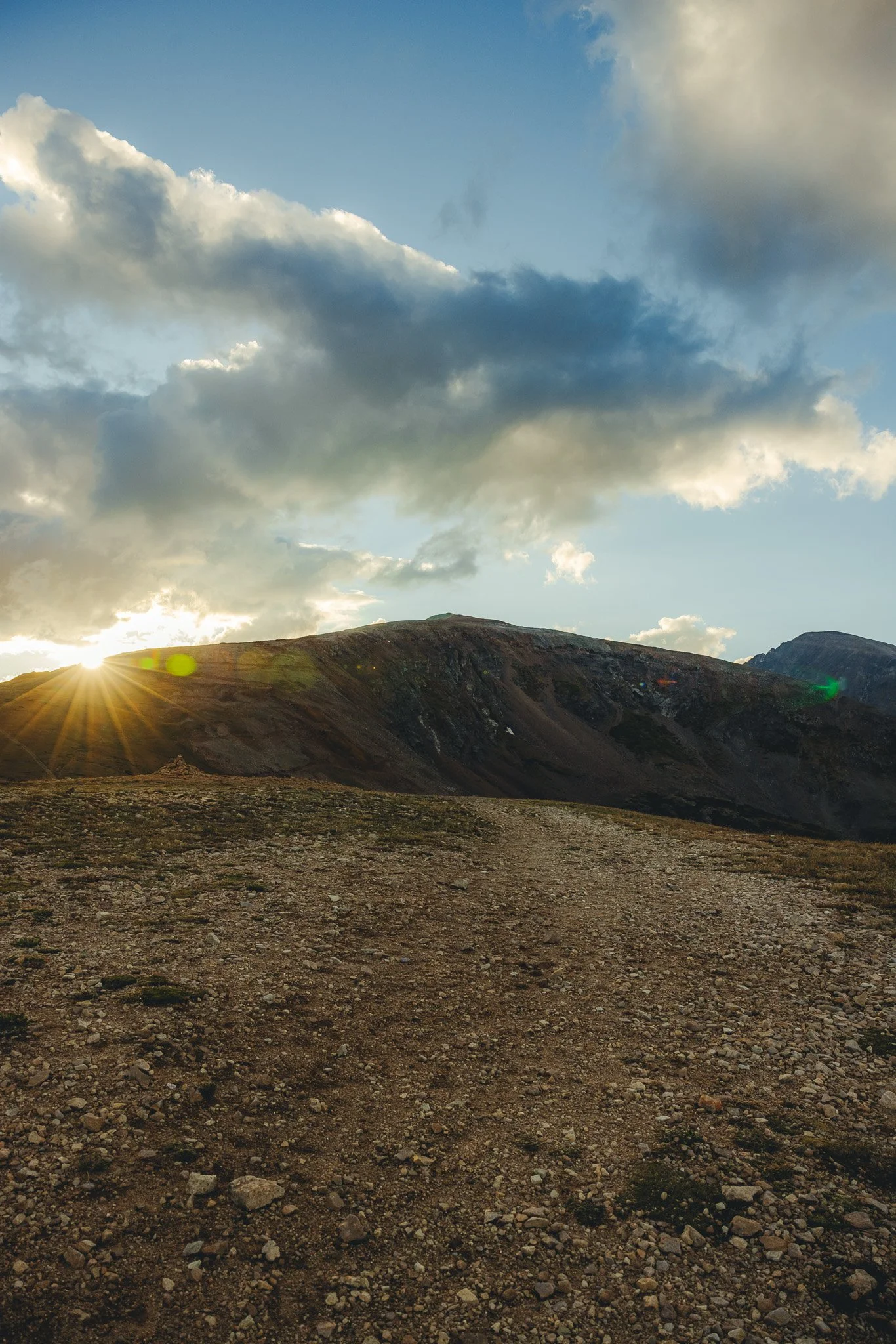 The sun peaking through the mountain peaks