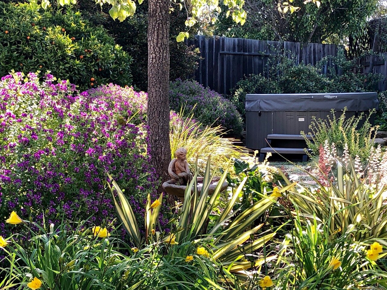 Tucked into a secluded corner at the back of the yard, this above-ground spa has a rewarding view of the garden.